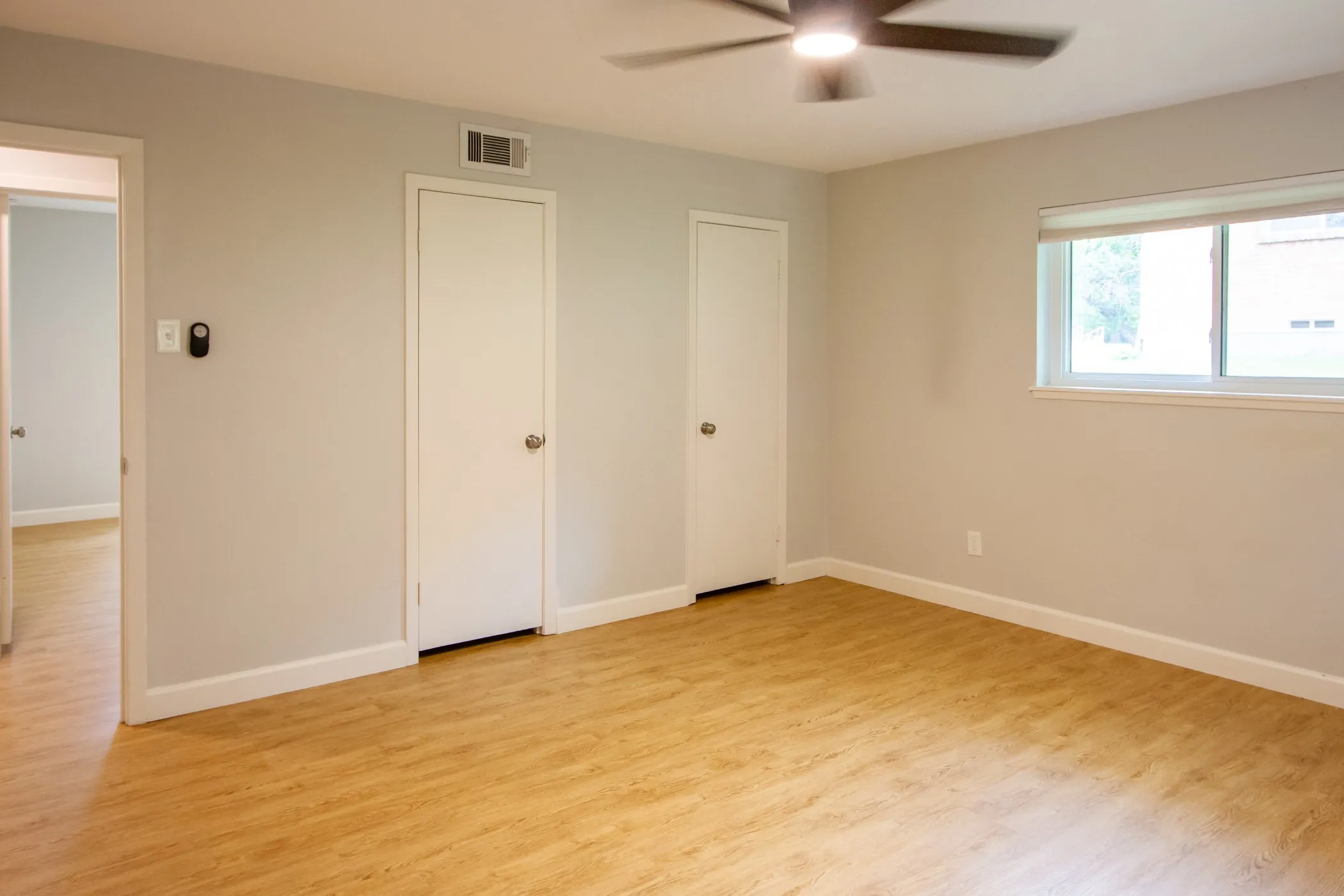 Unfurnished bedroom with light wood-style flooring, baseboards, and a ceiling fan