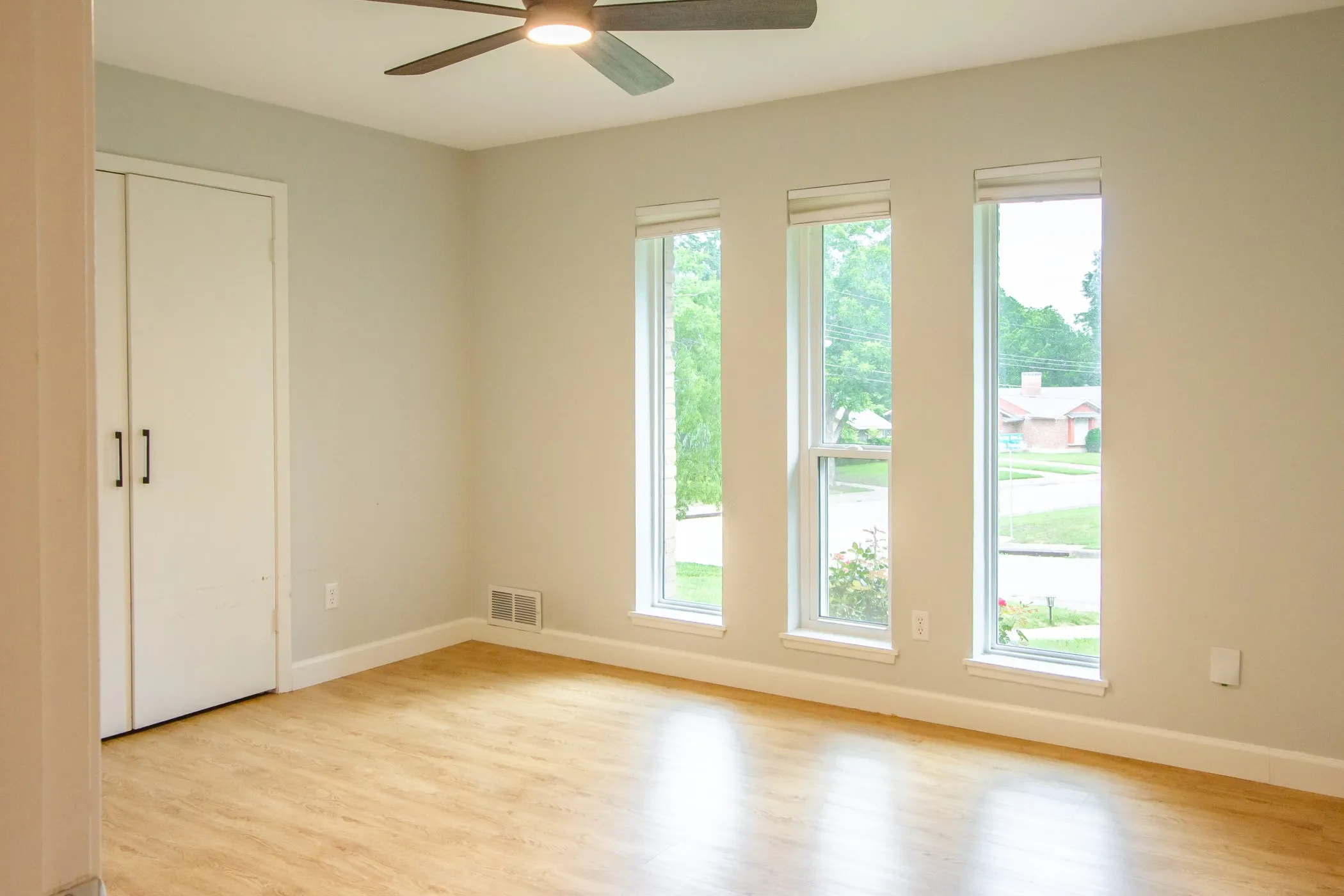 Spare room with light wood-style flooring, a ceiling fan, and baseboards