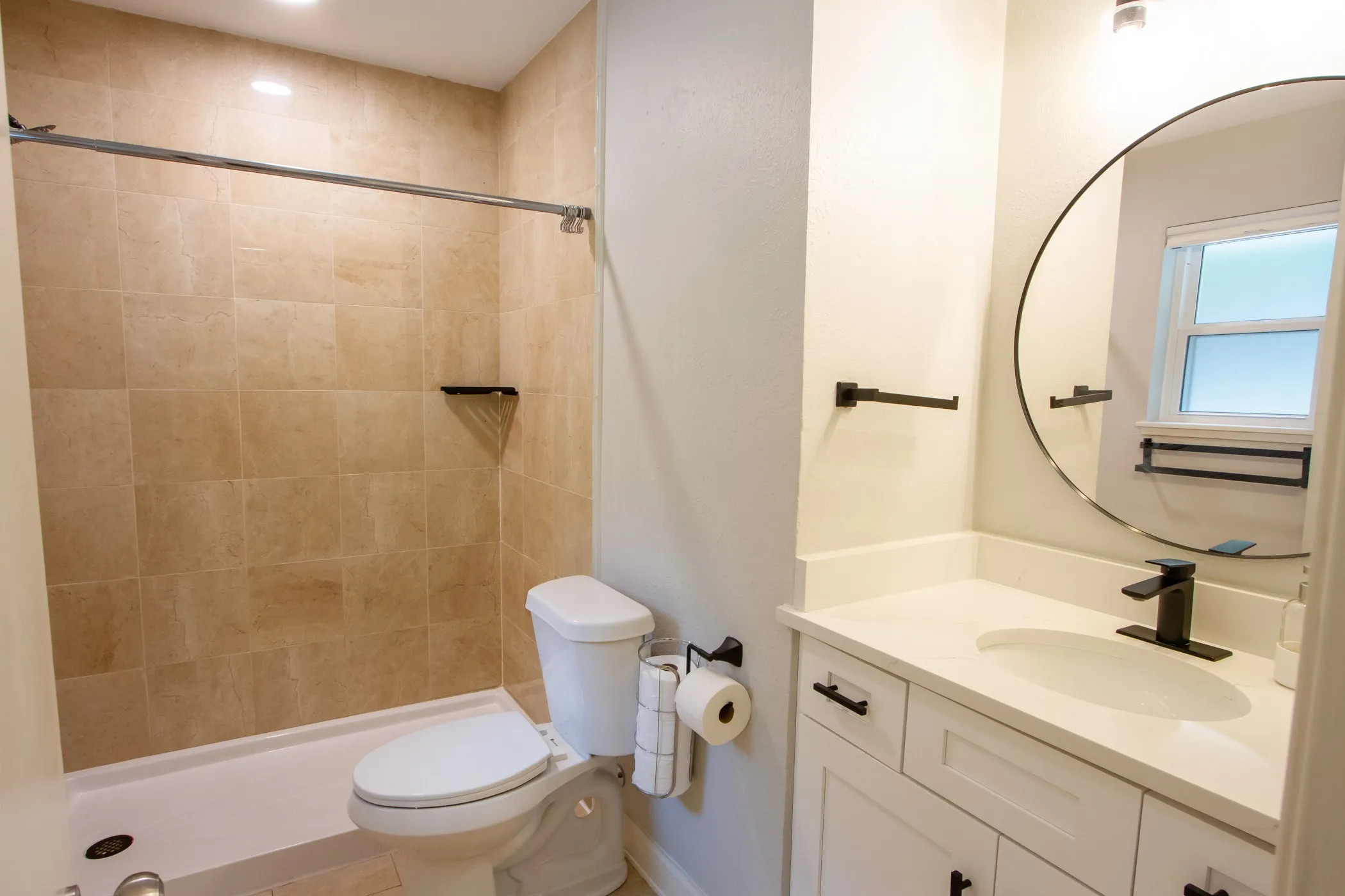 Full bathroom featuring vanity, toilet, a tile shower, and baseboards