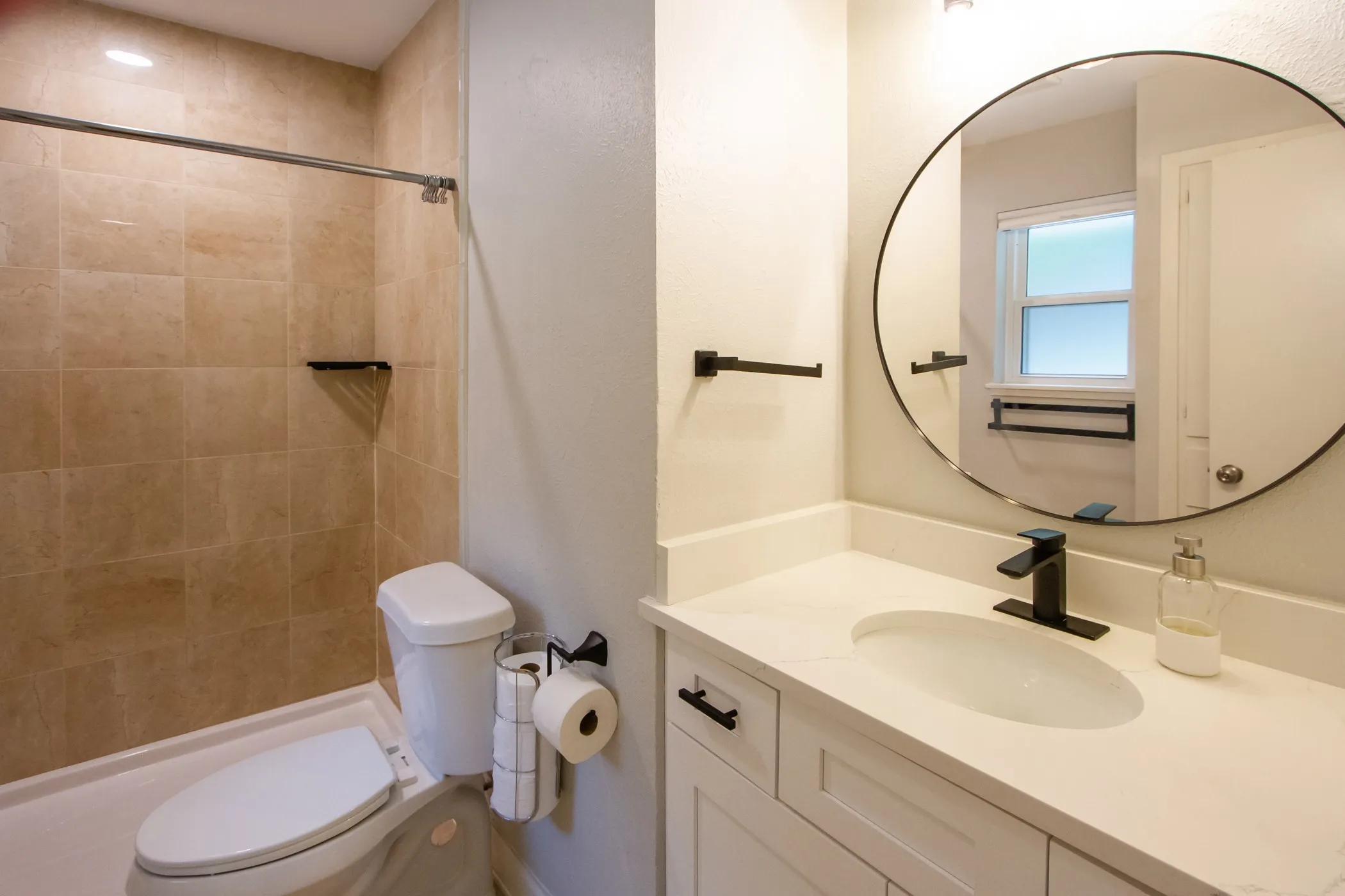 Bathroom with toilet, vanity, and tiled shower