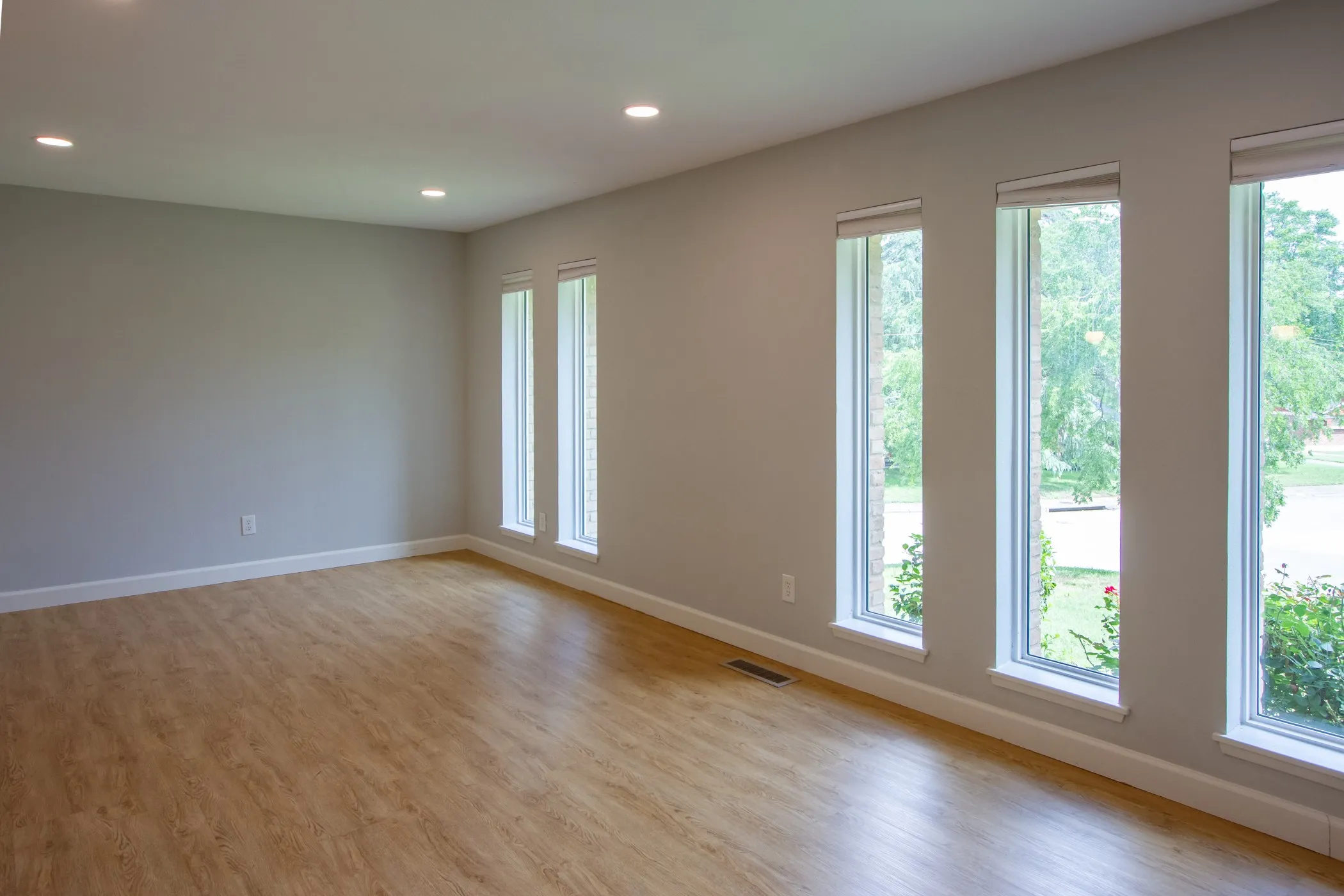 Spare room with baseboards, light wood-style floors, and recessed lighting