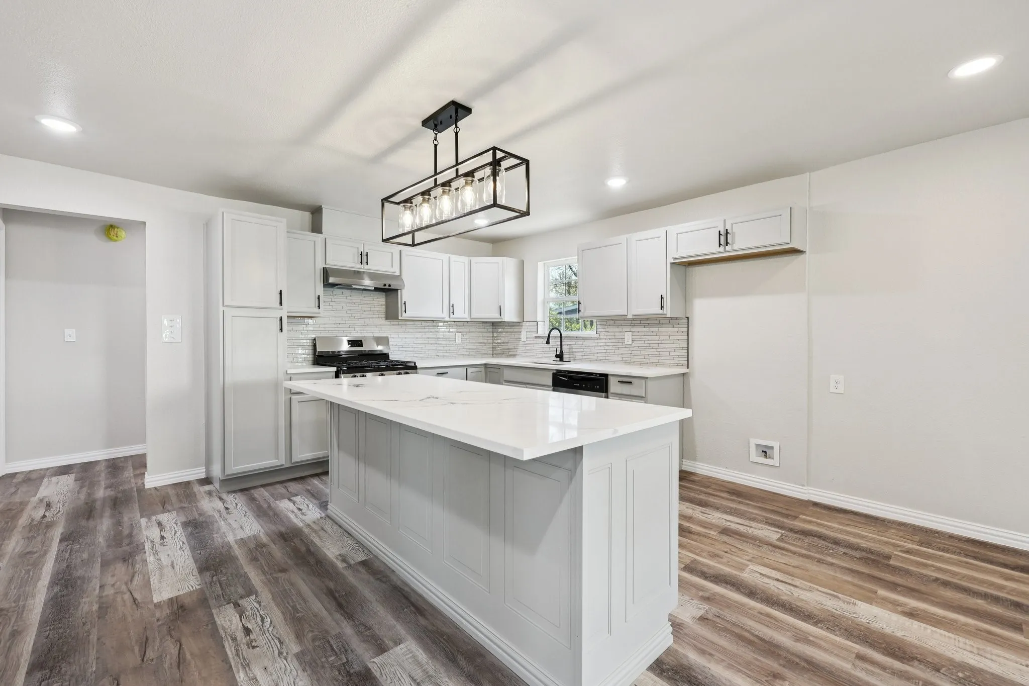Modern kitchen featuring a central island with a white countertop