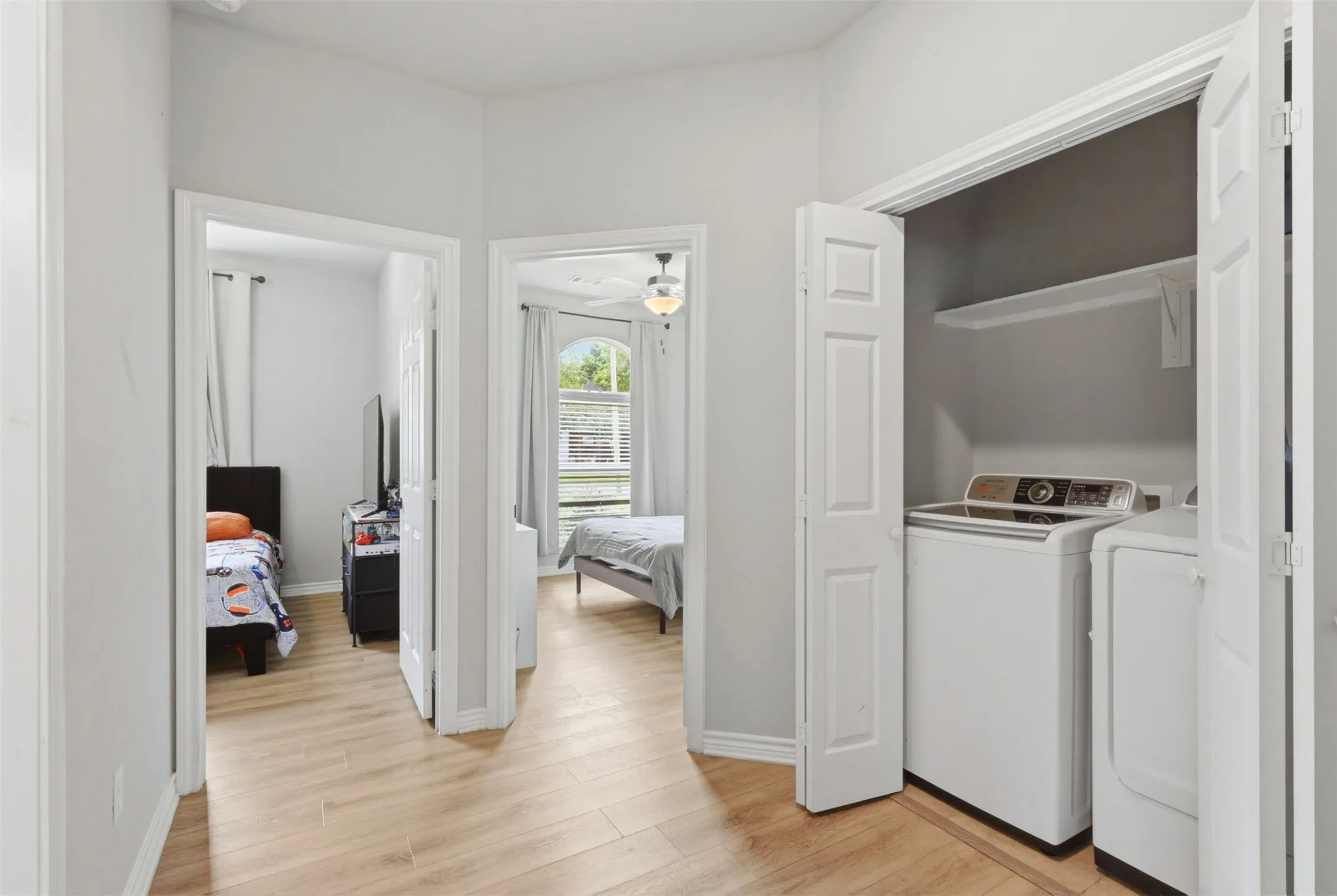 Dedicated laundry closet with bi-fold doors and integrated shelving