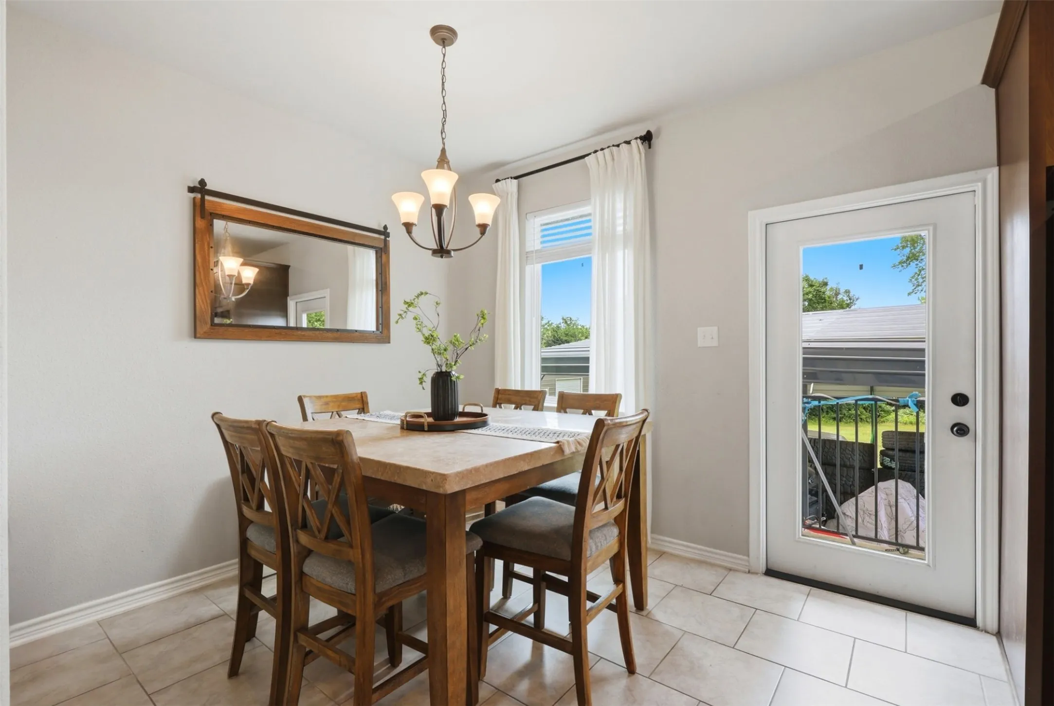 Dining area featuring neutral wall paint, tile flooring, and a glass-paned exterior door