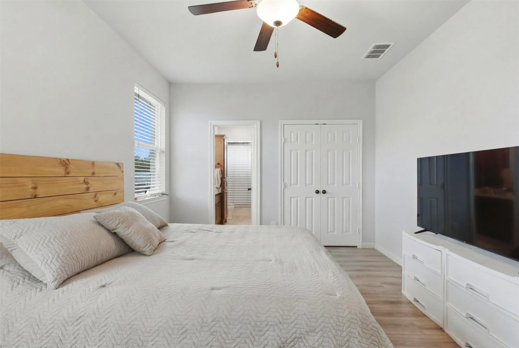 Bedroom featuring light wood-finish flooring and a ceiling fan with light fixture