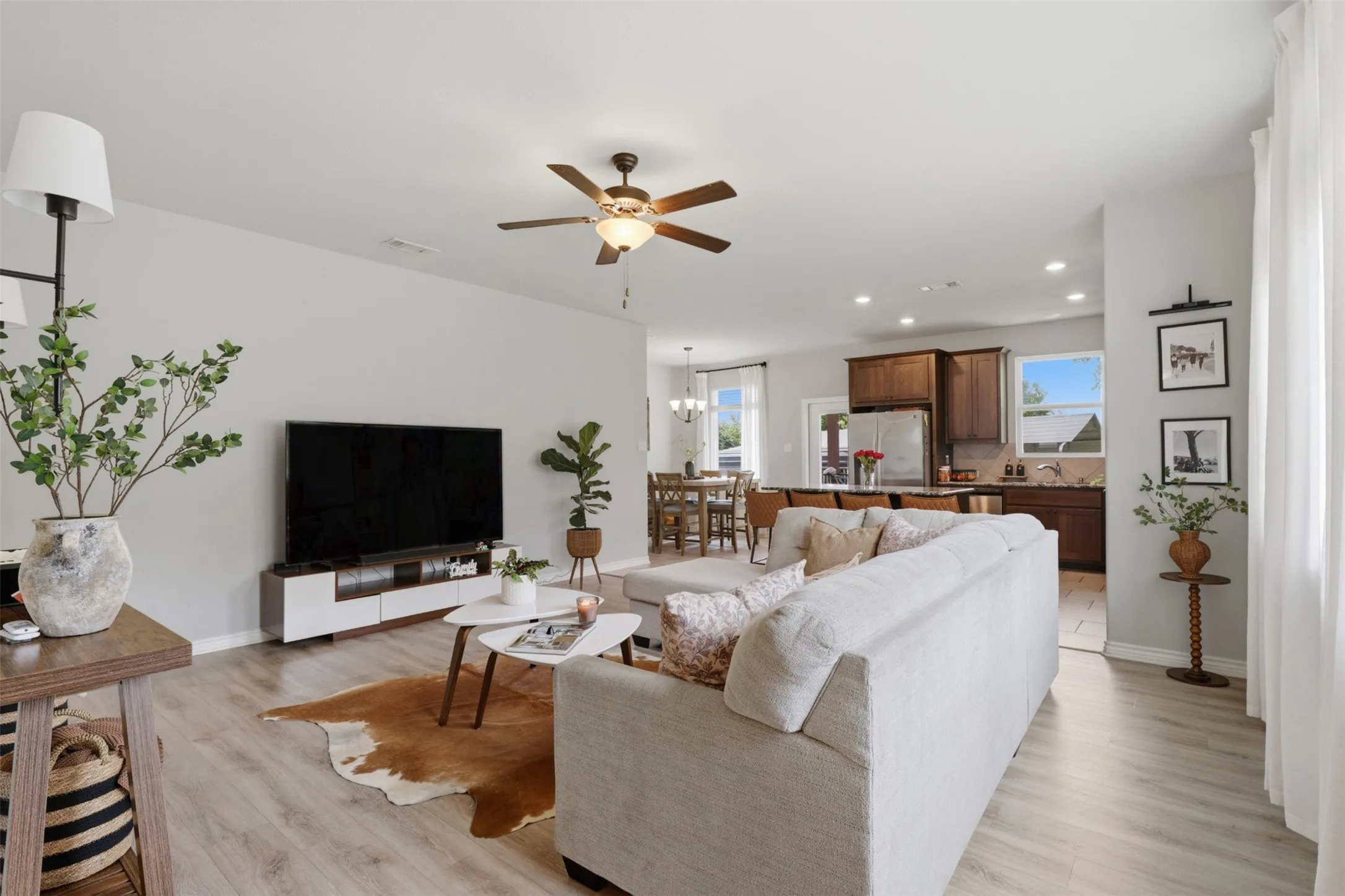 Expansive living area featuring light wood-finish flooring, recessed lighting, and a ceiling fan