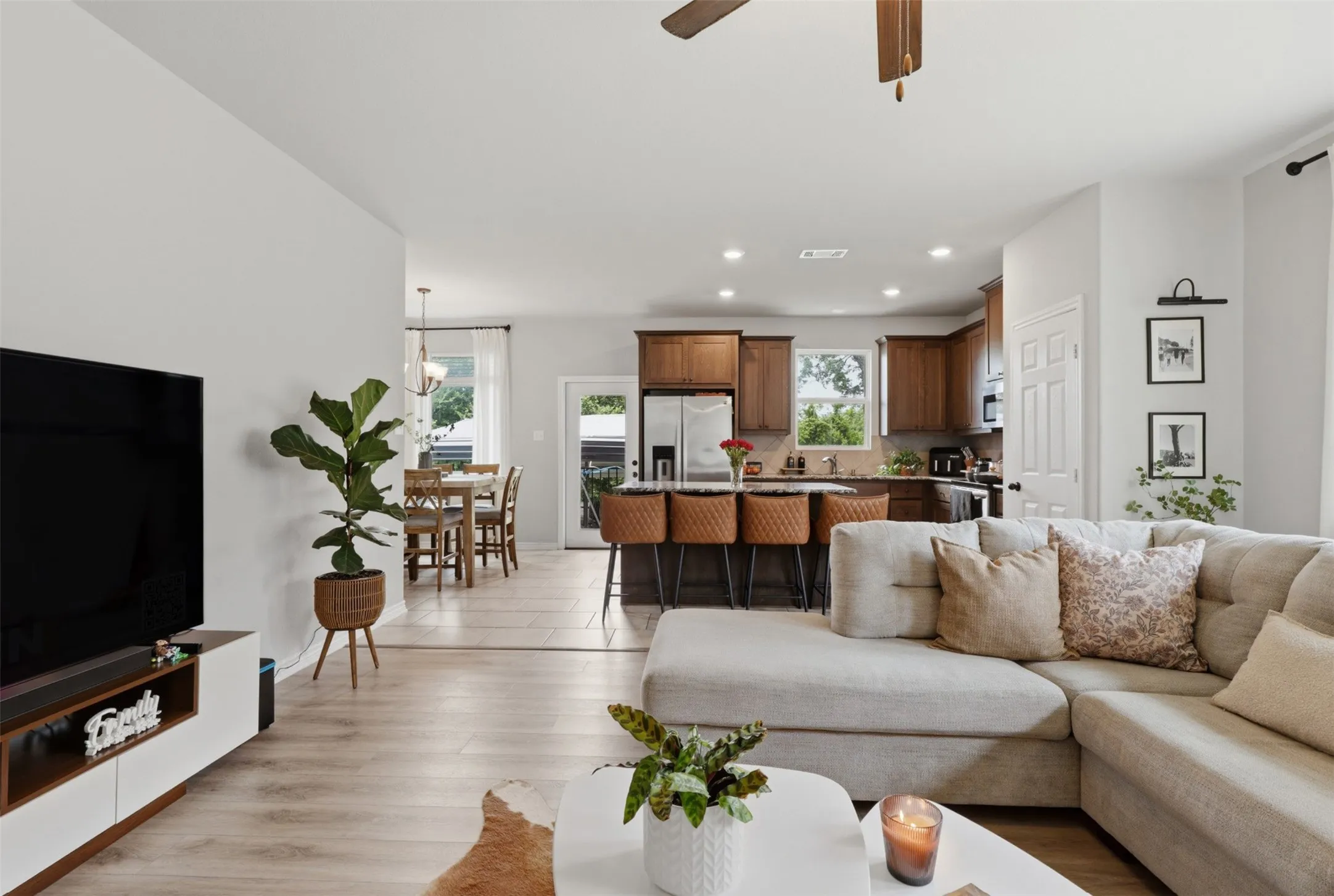 Expansive open-concept living area featuring light wood-finish flooring, a contemporary ceiling fan, and recessed lighting
