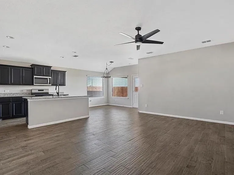 Open-concept living space featuring wood-finish flooring, a contemporary ceiling fan, and recessed lighting