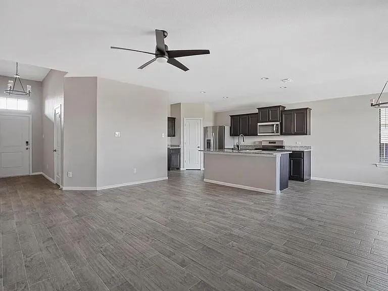 Open-concept living space featuring wood-finish flooring, a modern ceiling fan, and recessed lighting