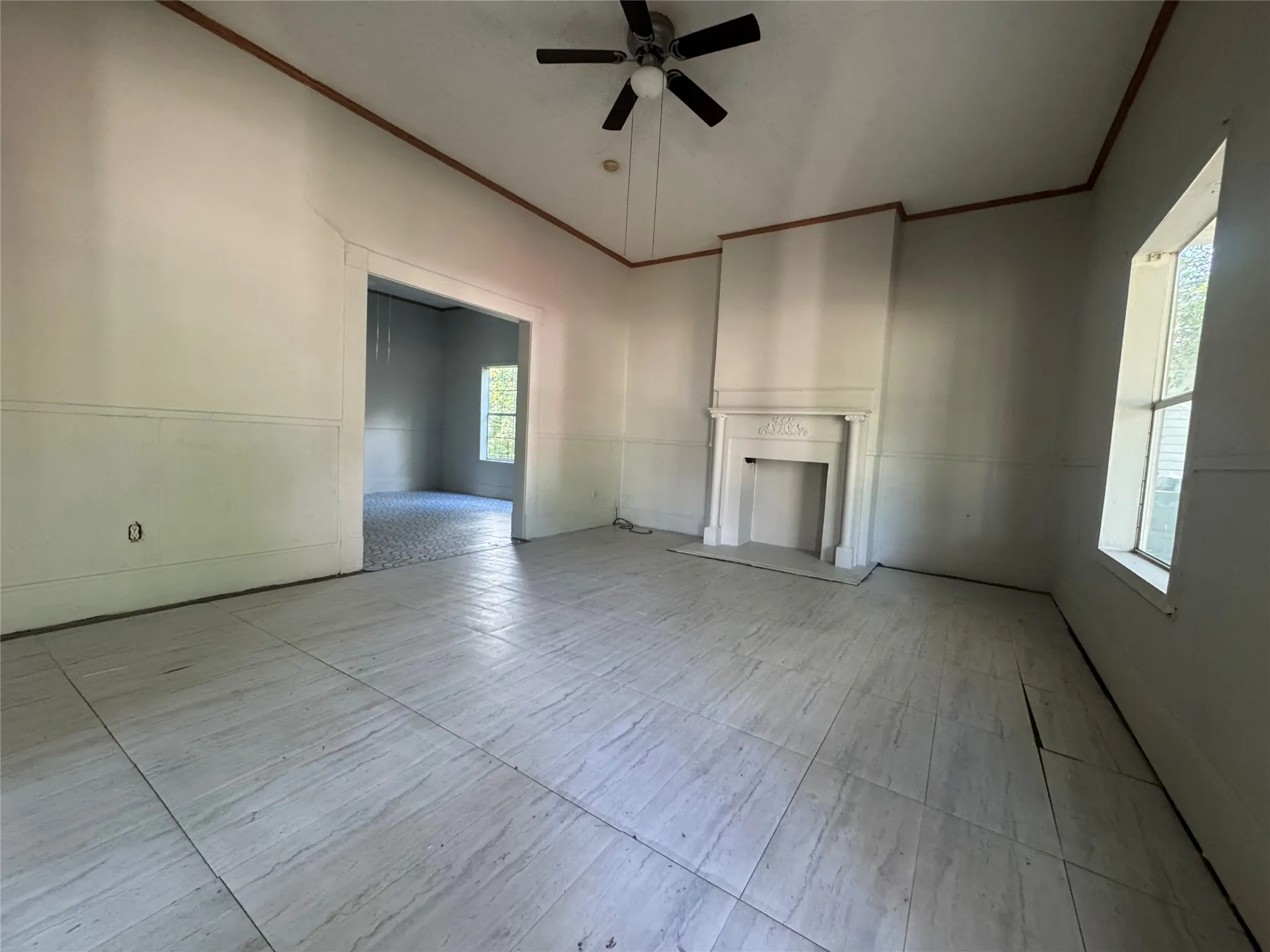 Spacious interior room featuring large format tile flooring and a decorative fireplace