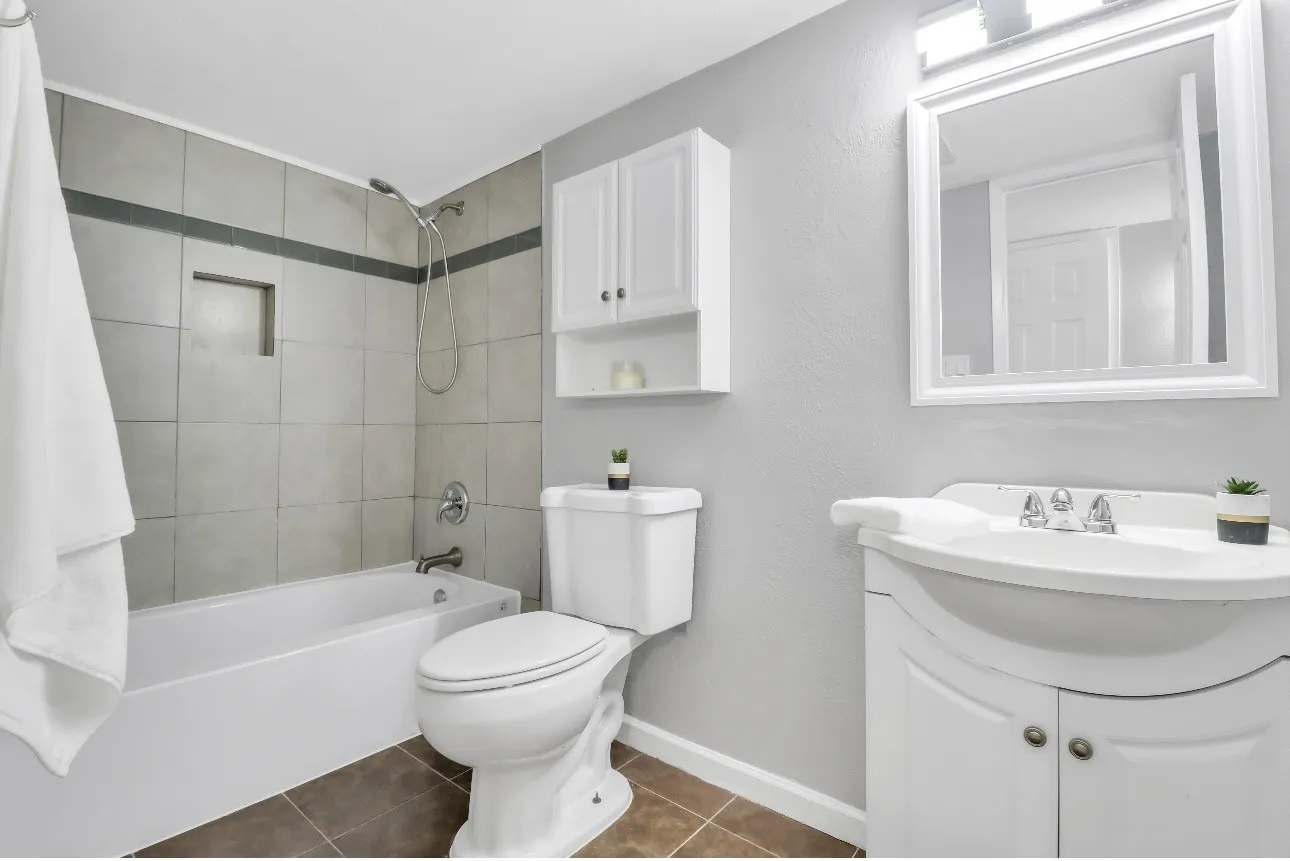 Full bathroom featuring a tub-shower combination with tiled surround, a recessed shower niche, and a wall-mounted shower head
