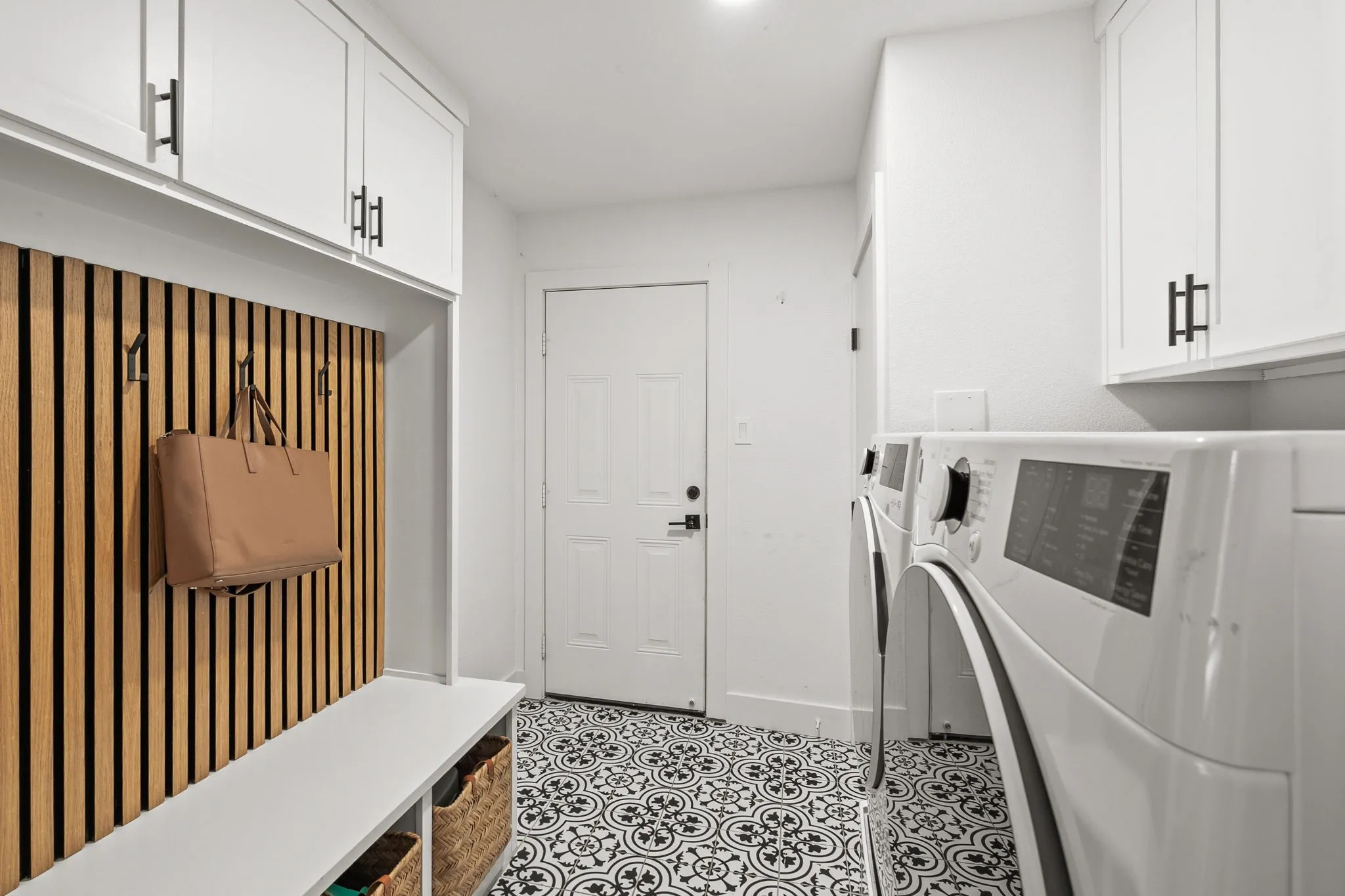 Mudroom with built-in bench, wood-slat wall paneling, and storage cubbies