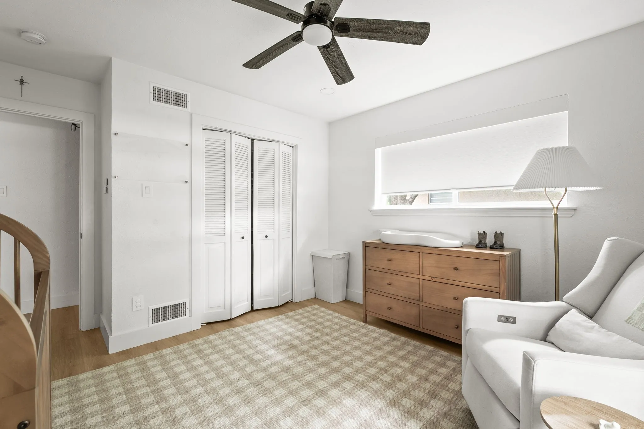 Bright room featuring wood-finish flooring and a ceiling fan with integrated lighting