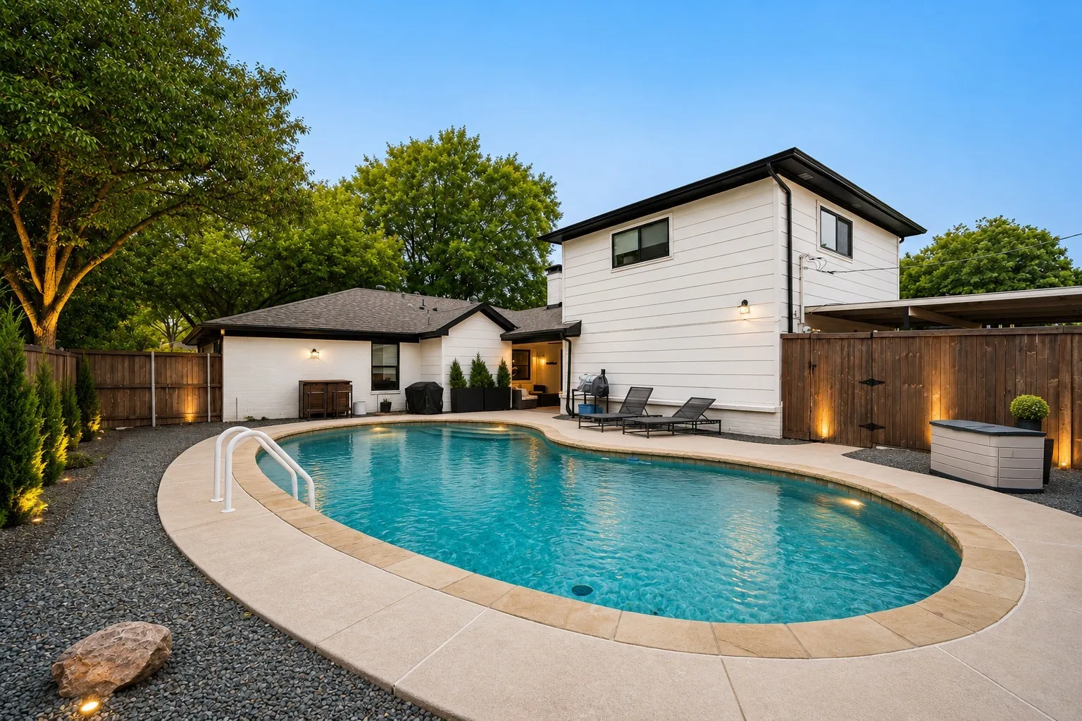 Oval-shaped swimming pool with a concrete surround and integrated steps