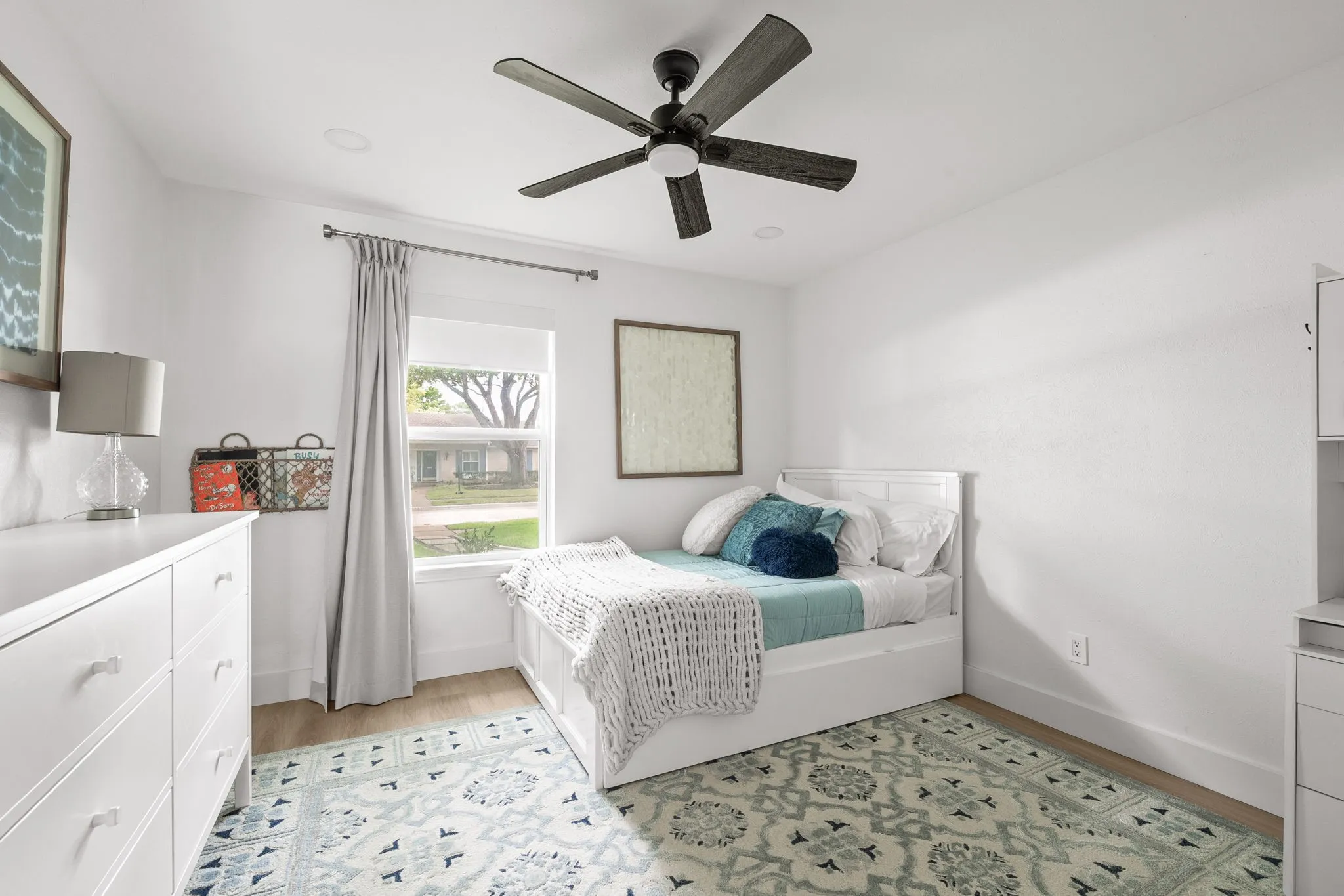 Bright room featuring wood-finish flooring and a ceiling fan