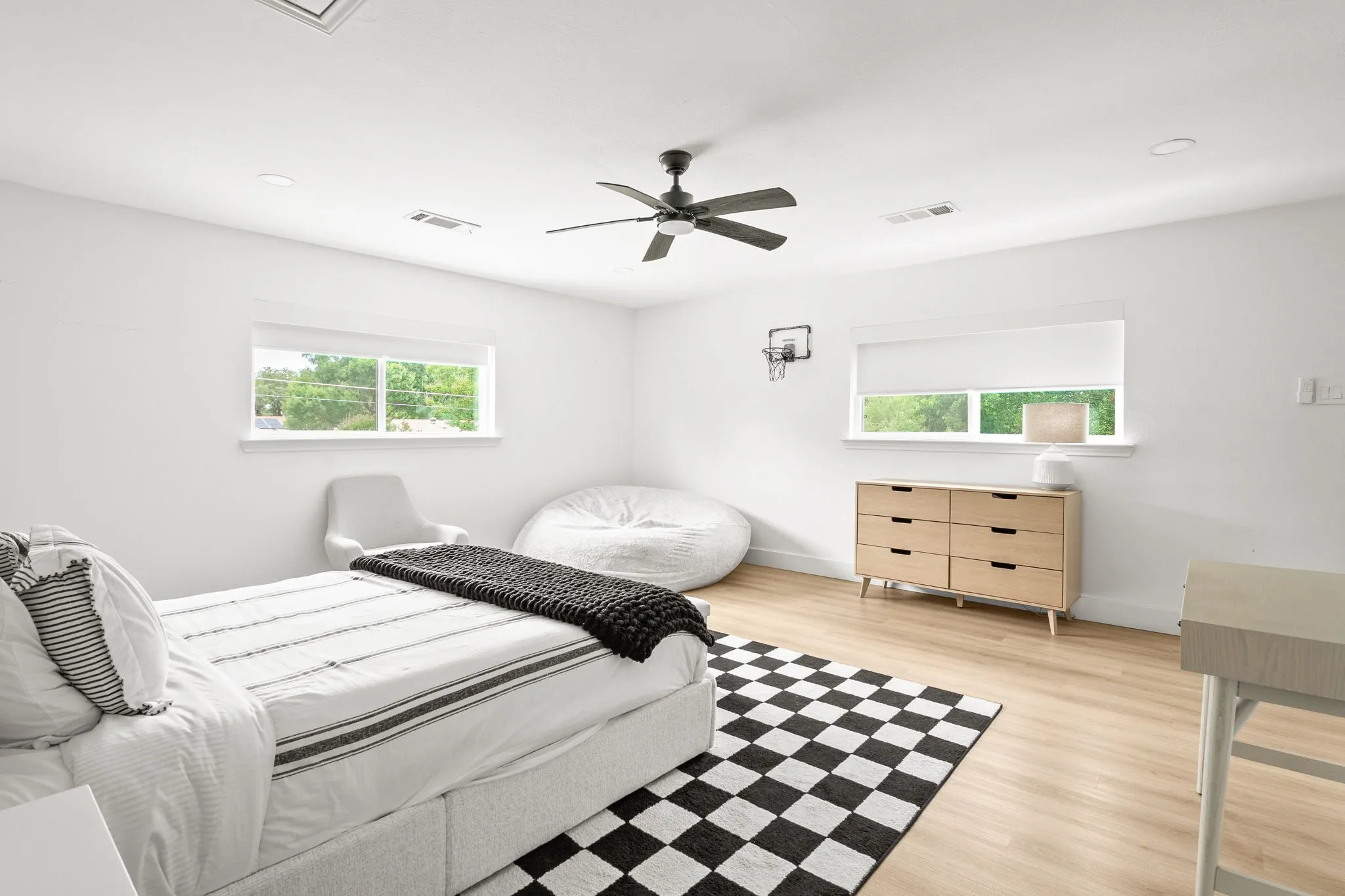 Spacious room featuring light wood-finish flooring and crisp white walls