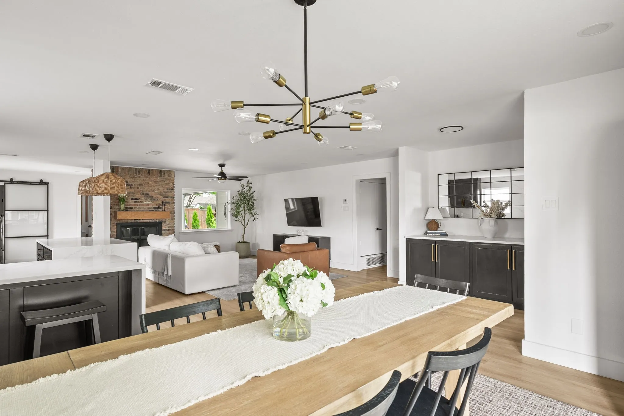 Open-concept dining and living areas featuring wood-finish flooring