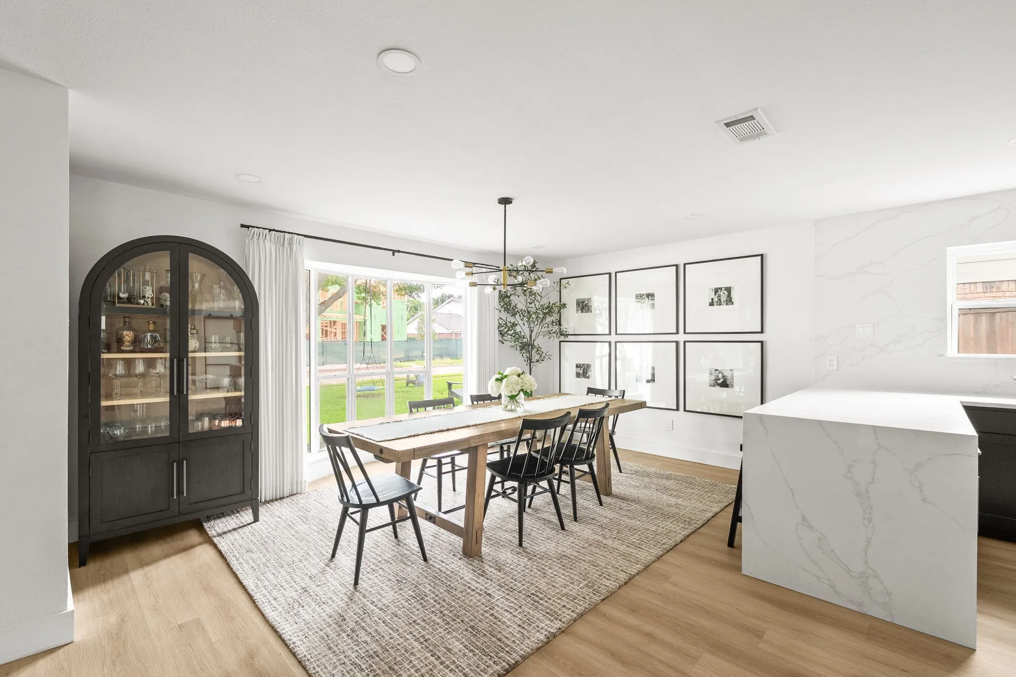Open-concept room featuring wood-finish flooring, recessed lighting, and a large window overlooking the backyard