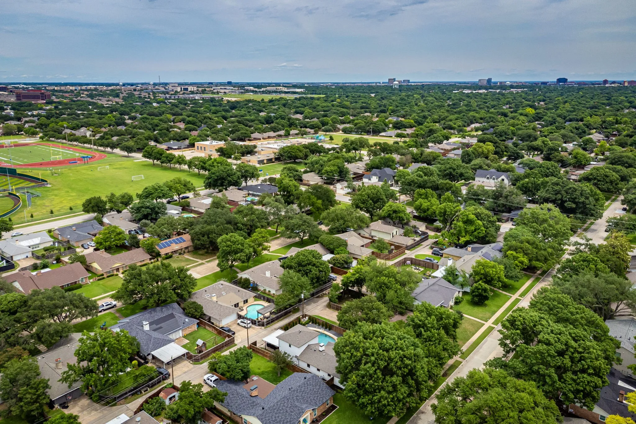 Aerial perspective showcasing a residential area with mature tree canopies