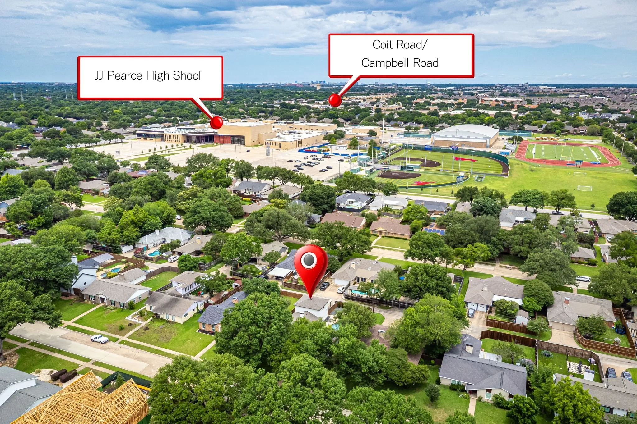 Aerial view of a residential neighborhood with a prominent high school facility visible, featuring a track and sports fields