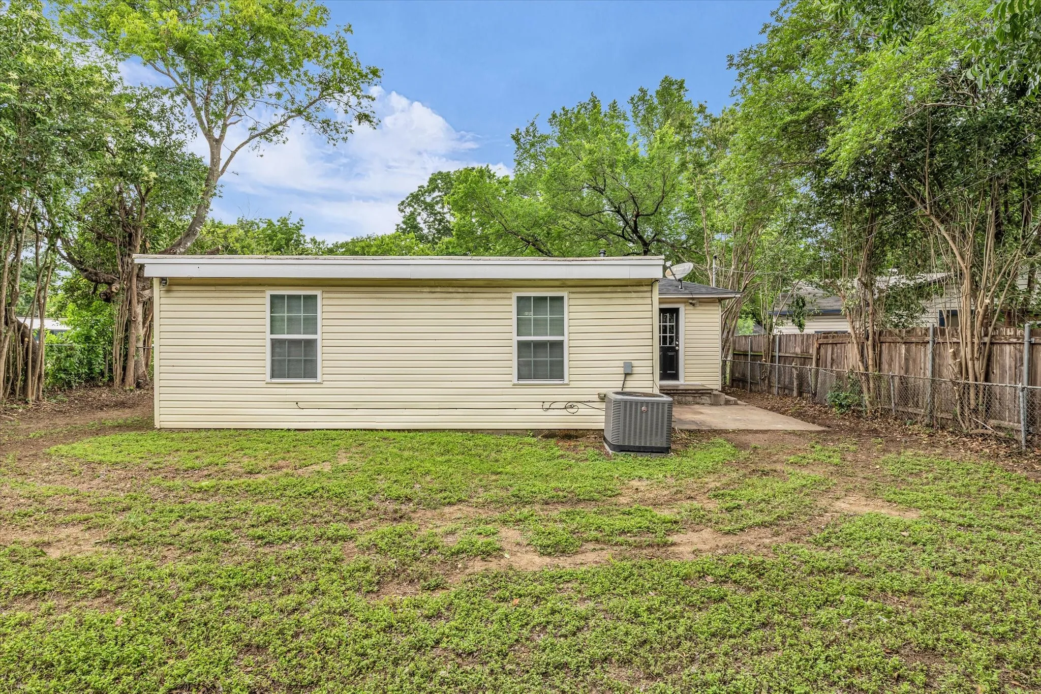 Expansive grassy yard with mature trees