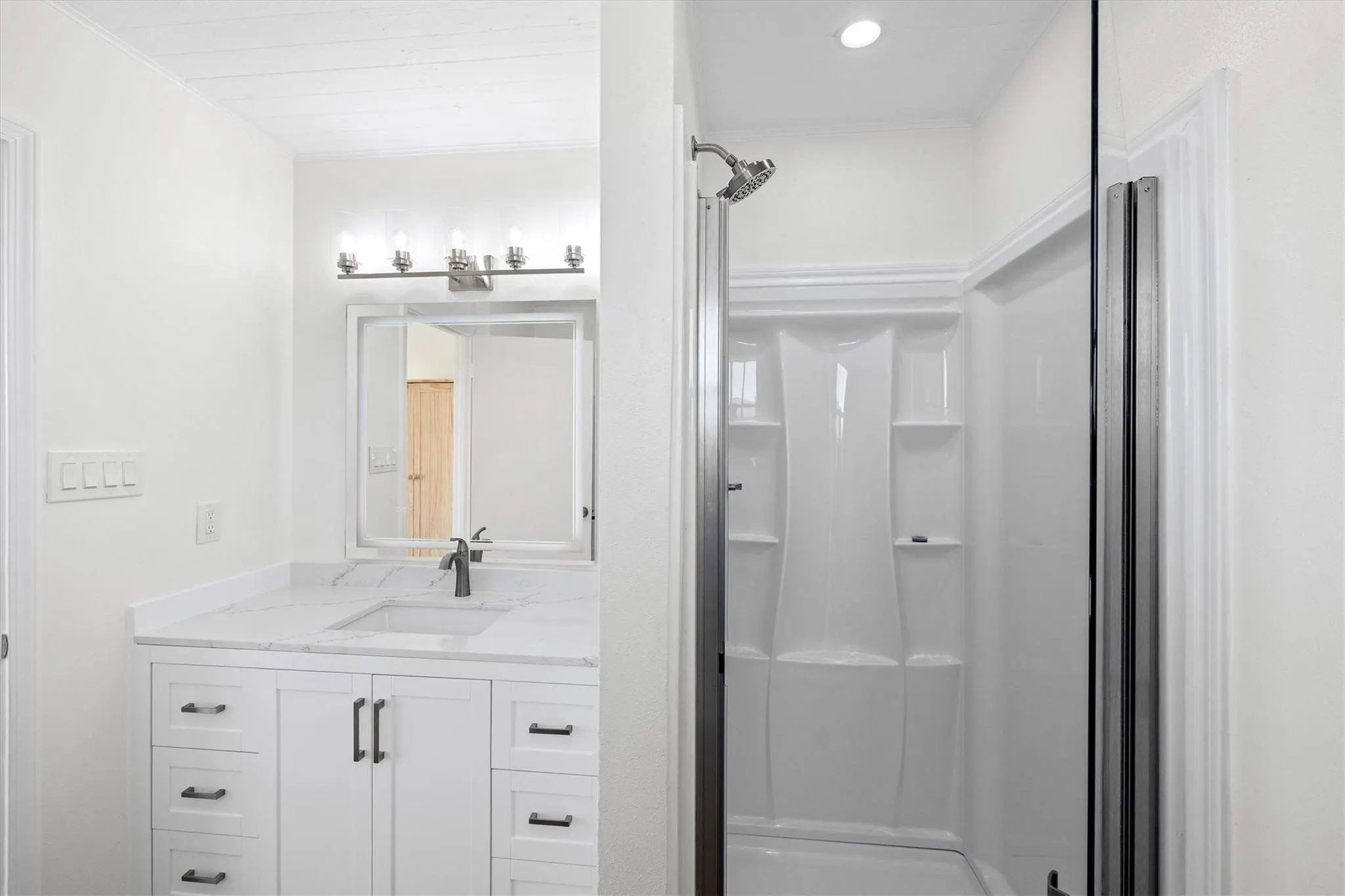 Bathroom featuring a white vanity with dark hardware, a rectangular sink, and a stone-finish countertop
