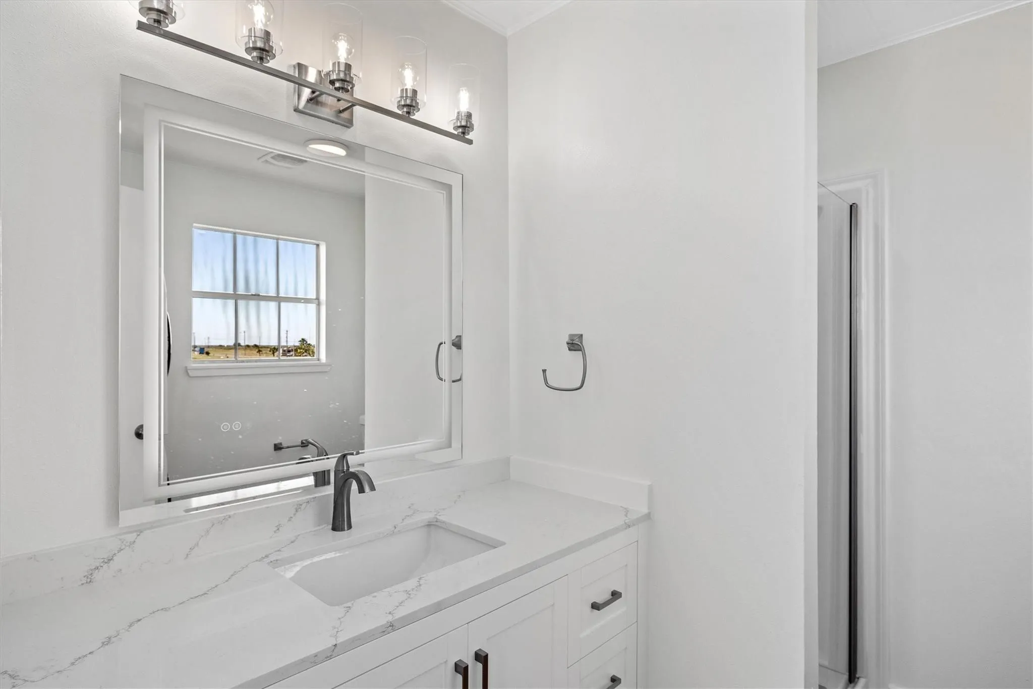 White vanity with integrated sink, quartz countertop, and matte black faucet