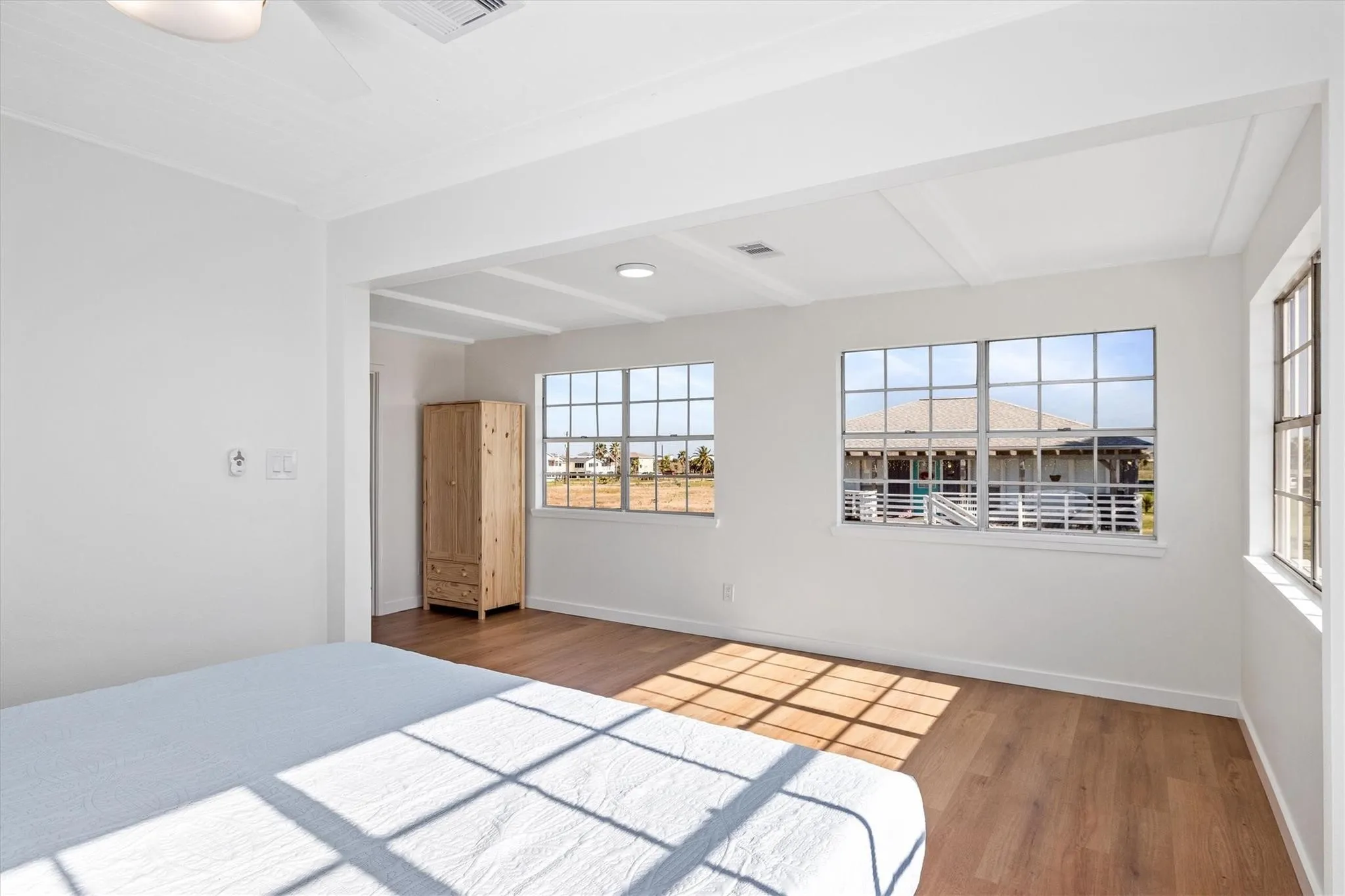 Bright interior space featuring white walls and wood-finish flooring