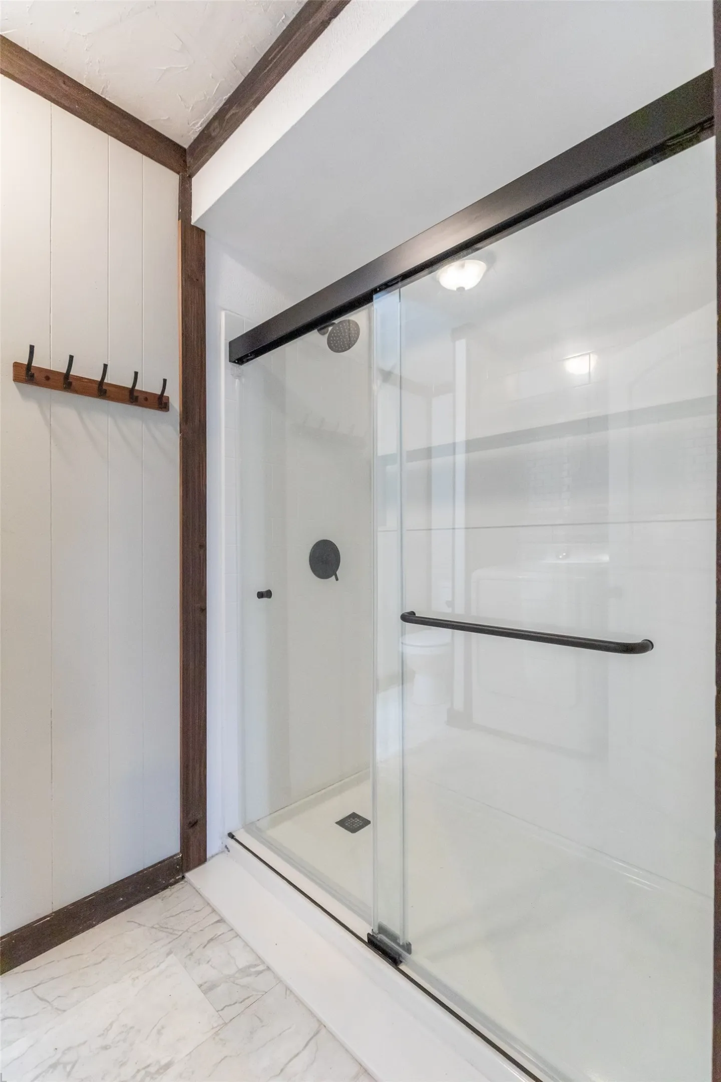 Shower enclosure with clear glass sliding doors and matte black hardware