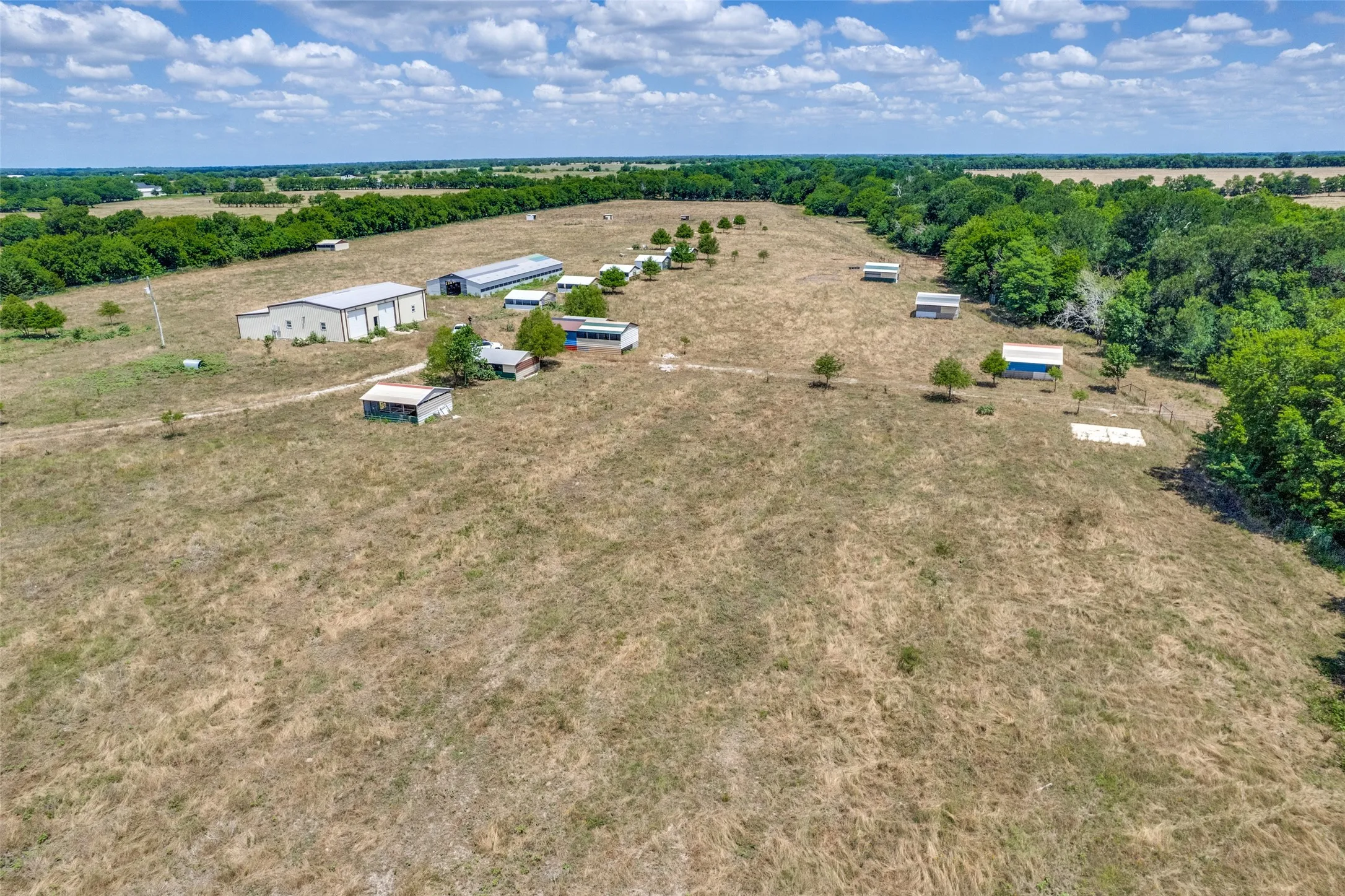 Expansive open fields with multiple outbuildings and structures