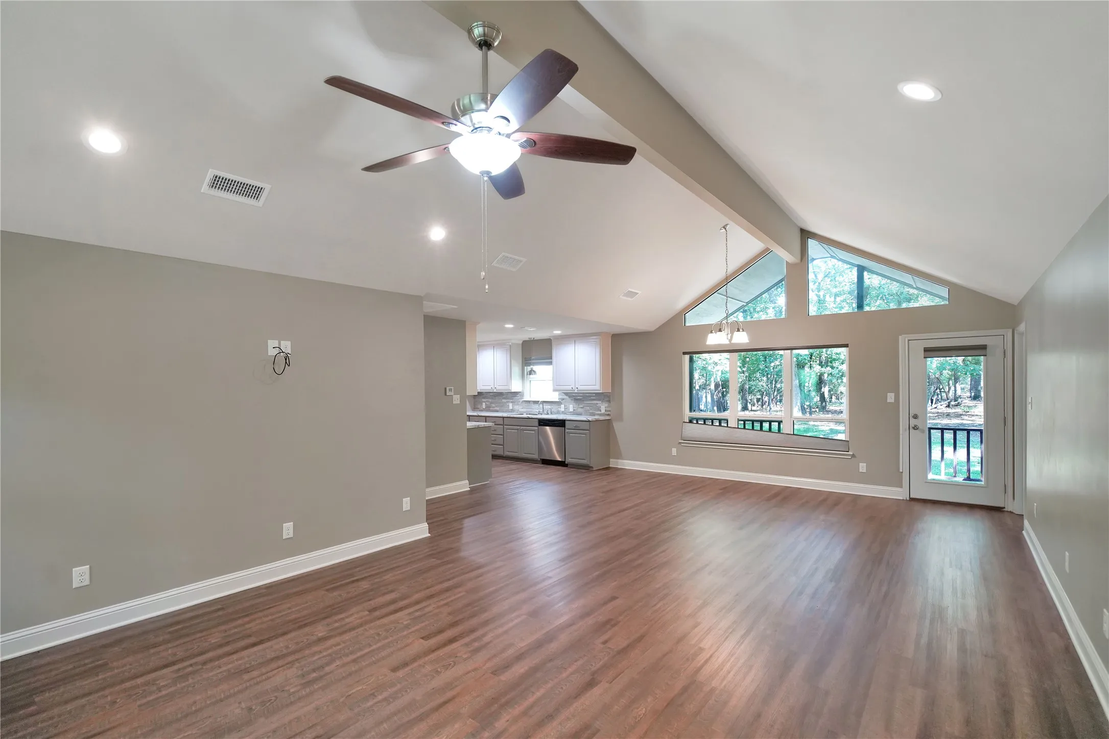 Vaulted ceiling living space featuring wood-finish flooring, recessed lighting, and a ceiling fan