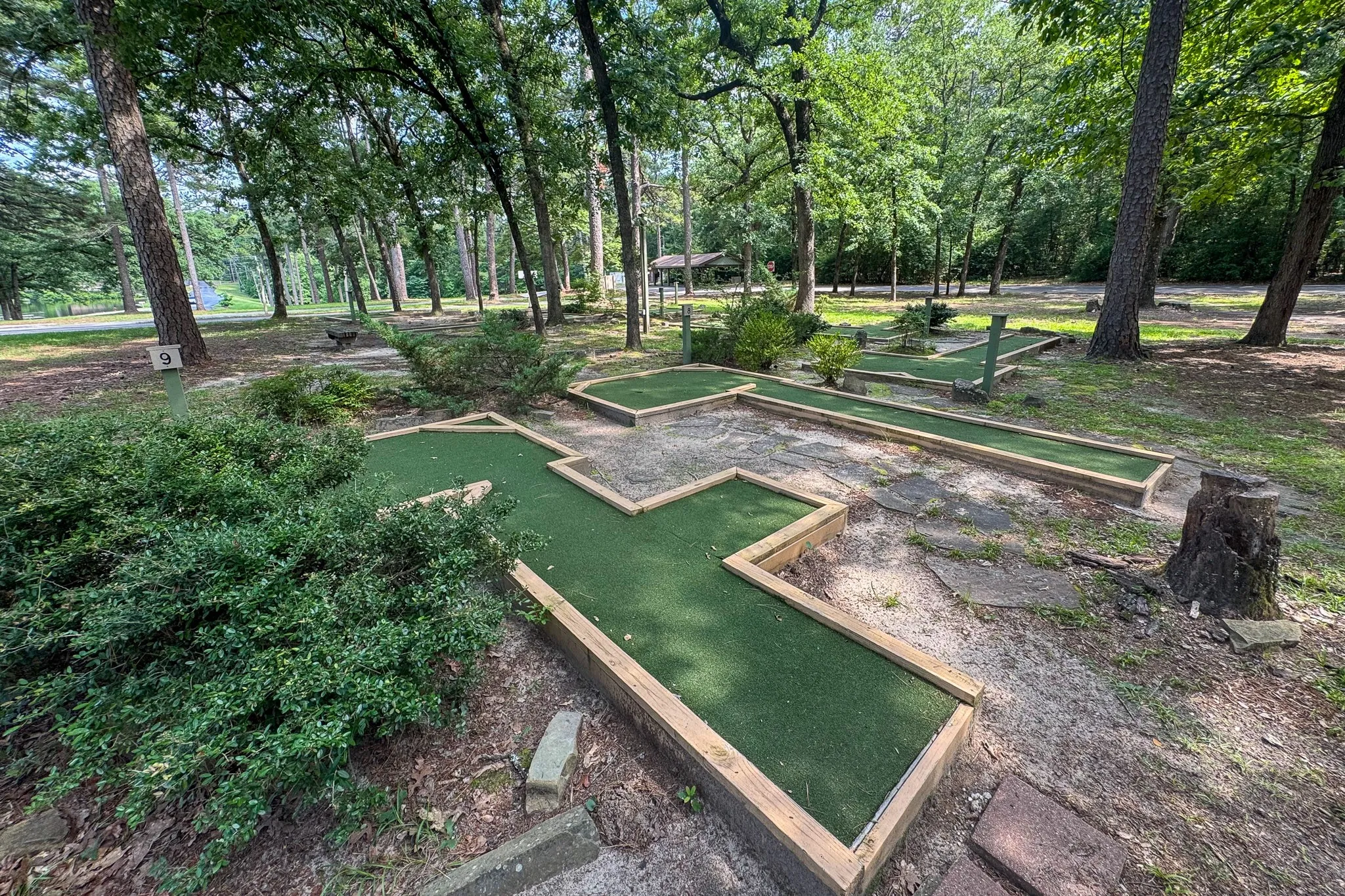 Outdoor putting green featuring artificial turf and natural wood borders