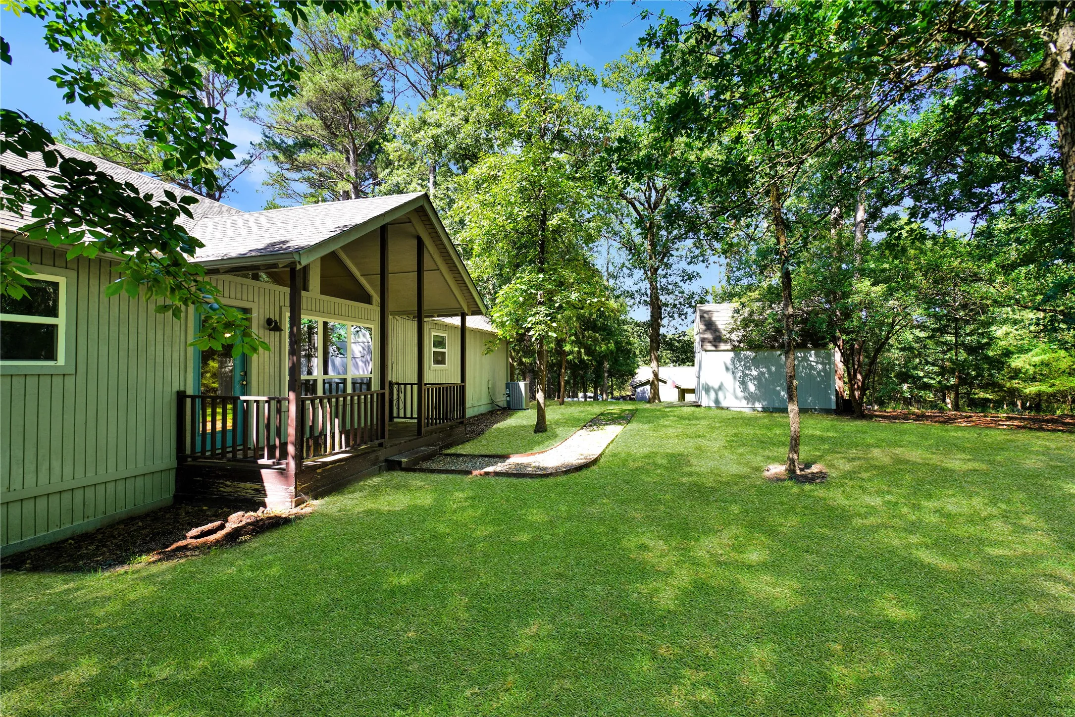 Ranch-style residence featuring vertical siding, a covered porch with a railing, and a gabled roofline