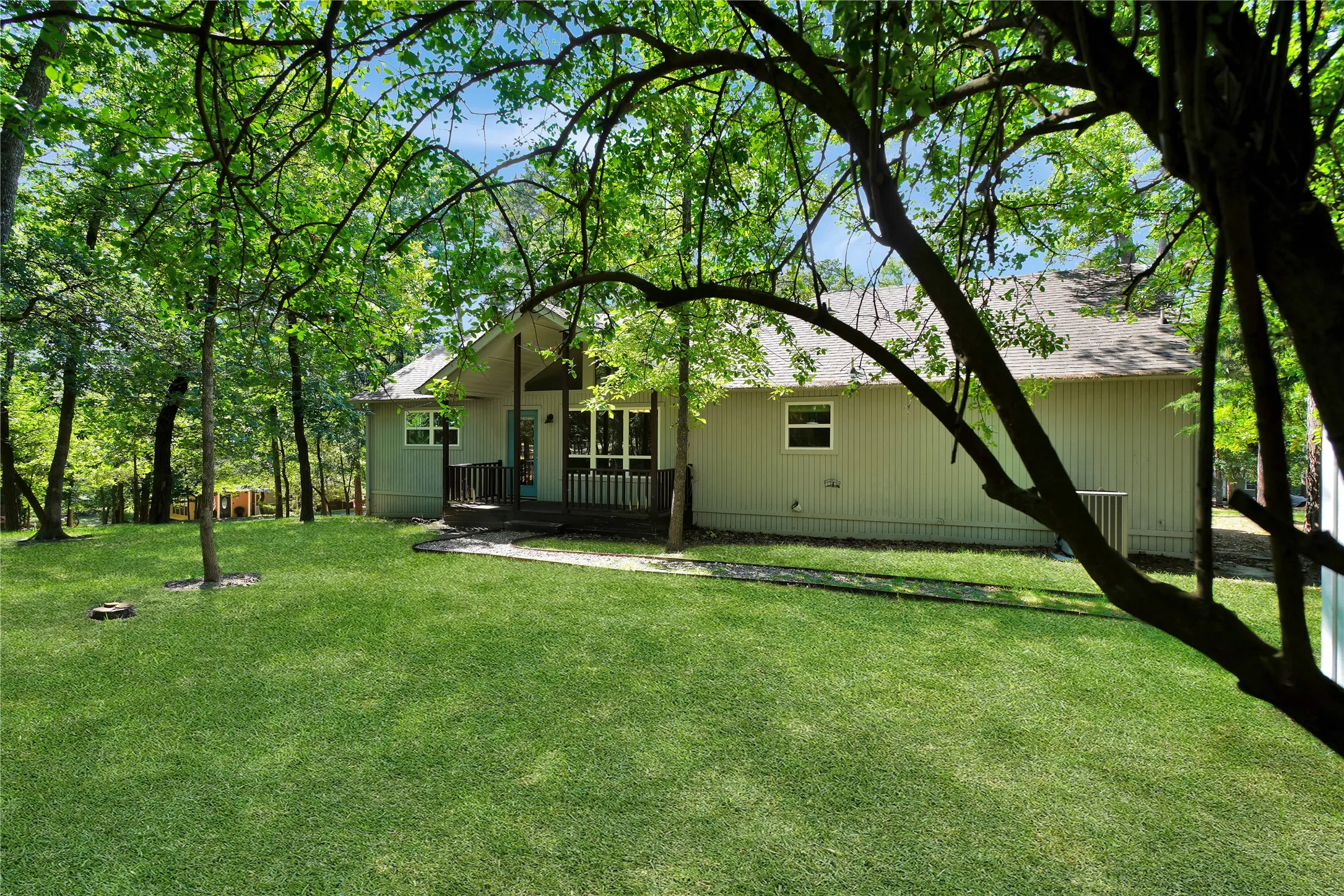 Exterior with light-colored siding, a dark-toned front porch, and a shingled roof