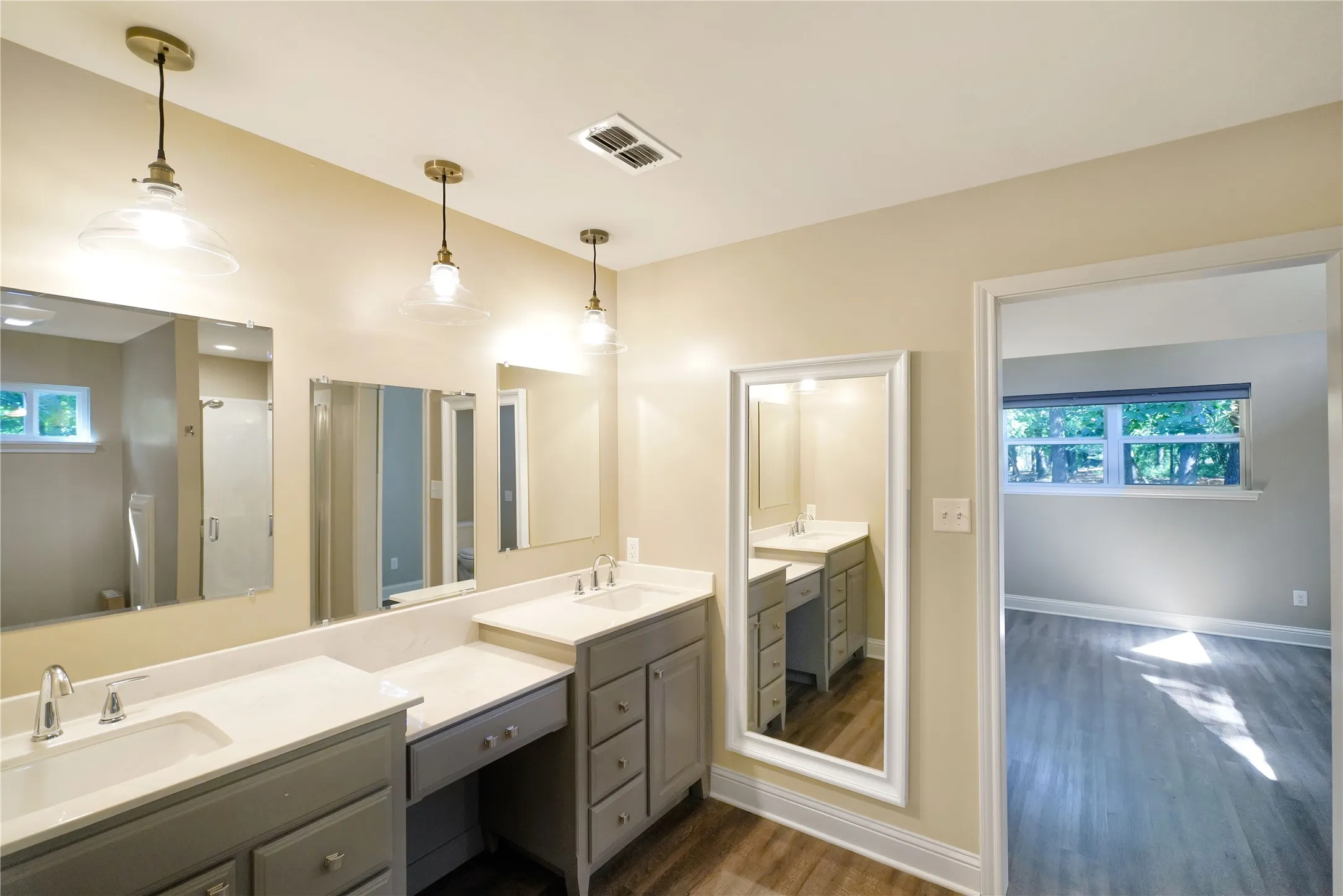 Bathroom featuring dual gray vanity cabinets with integrated sinks and expansive countertop space