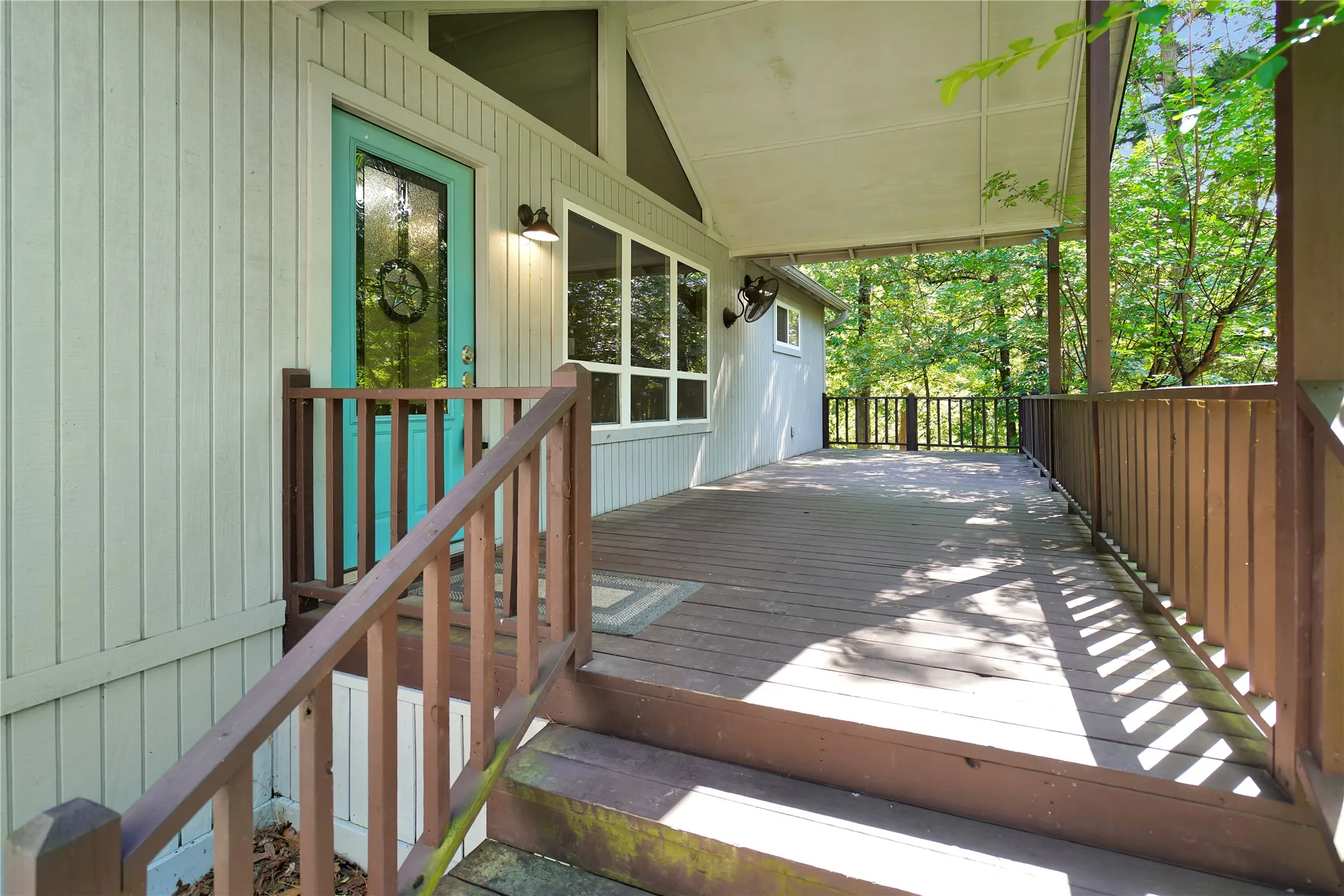 Expansive covered wood-finish deck with wood railings