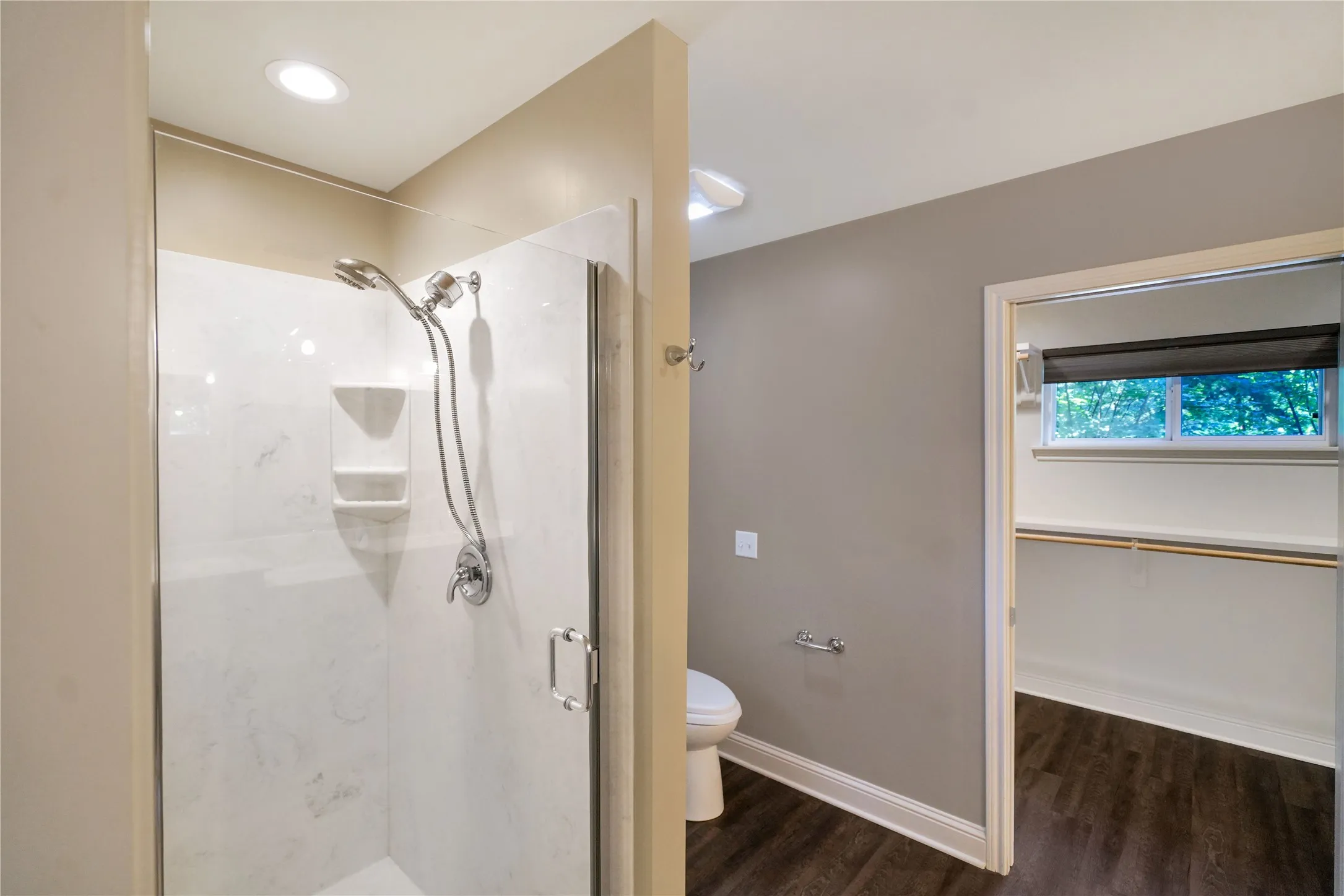 Walk-in shower with clear glass enclosure and built-in shelving
