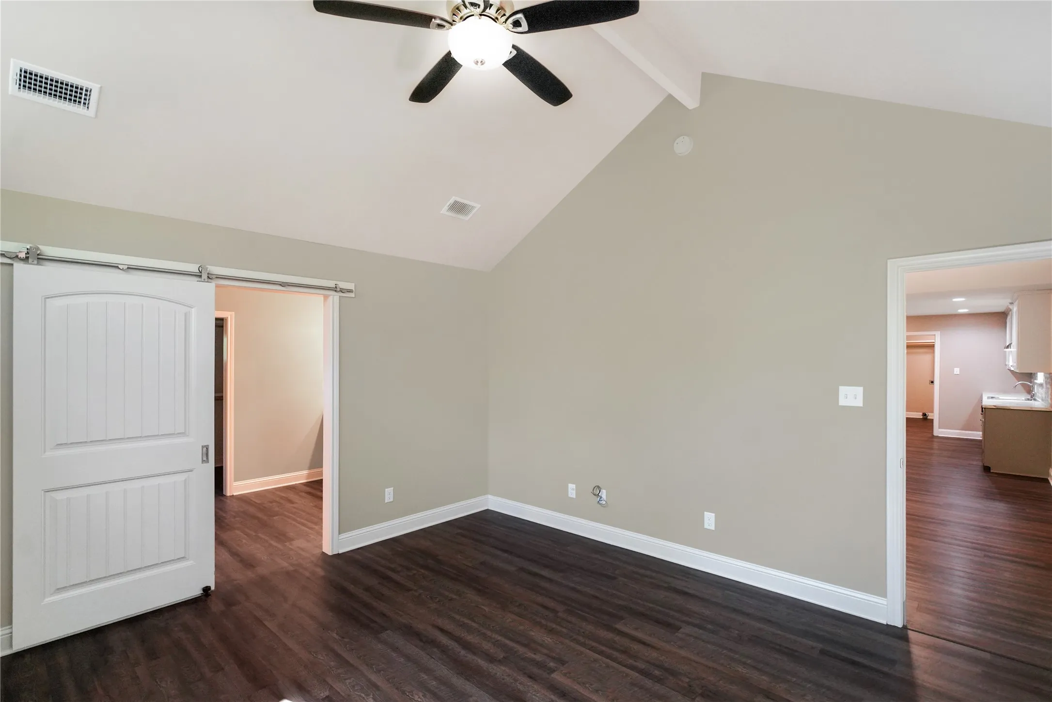 Vaulted ceiling with exposed beam and ceiling fan