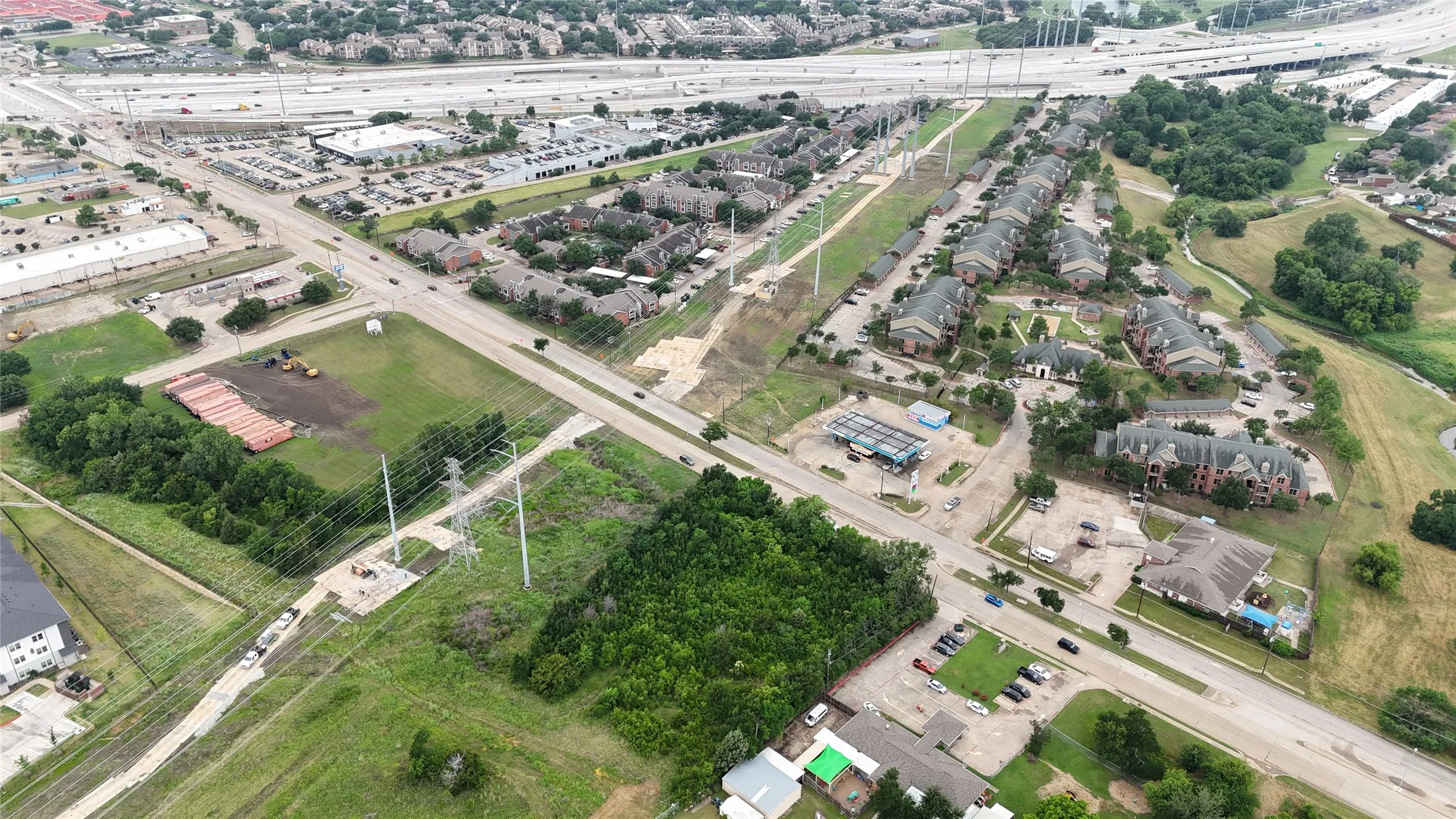 Aerial perspective showcasing a residential development surrounded by mature trees and open green spaces