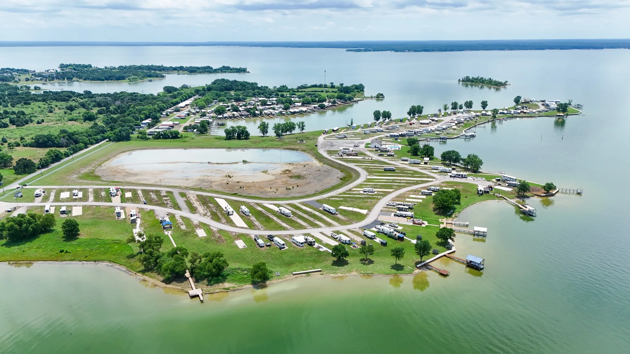 Expansive waterfront property featuring multiple boat docks, a large body of water, and numerous developed plots
