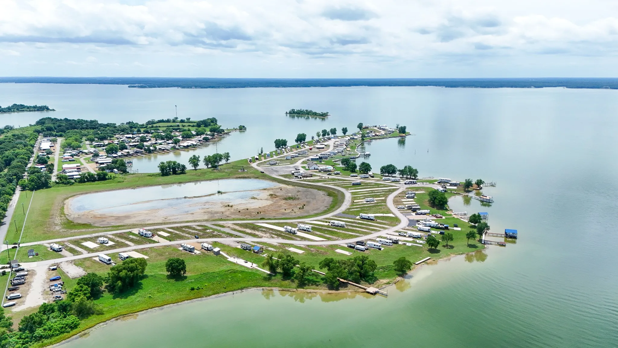 Expansive waterfront property featuring a large body of water, multiple docks, and a developed shoreline