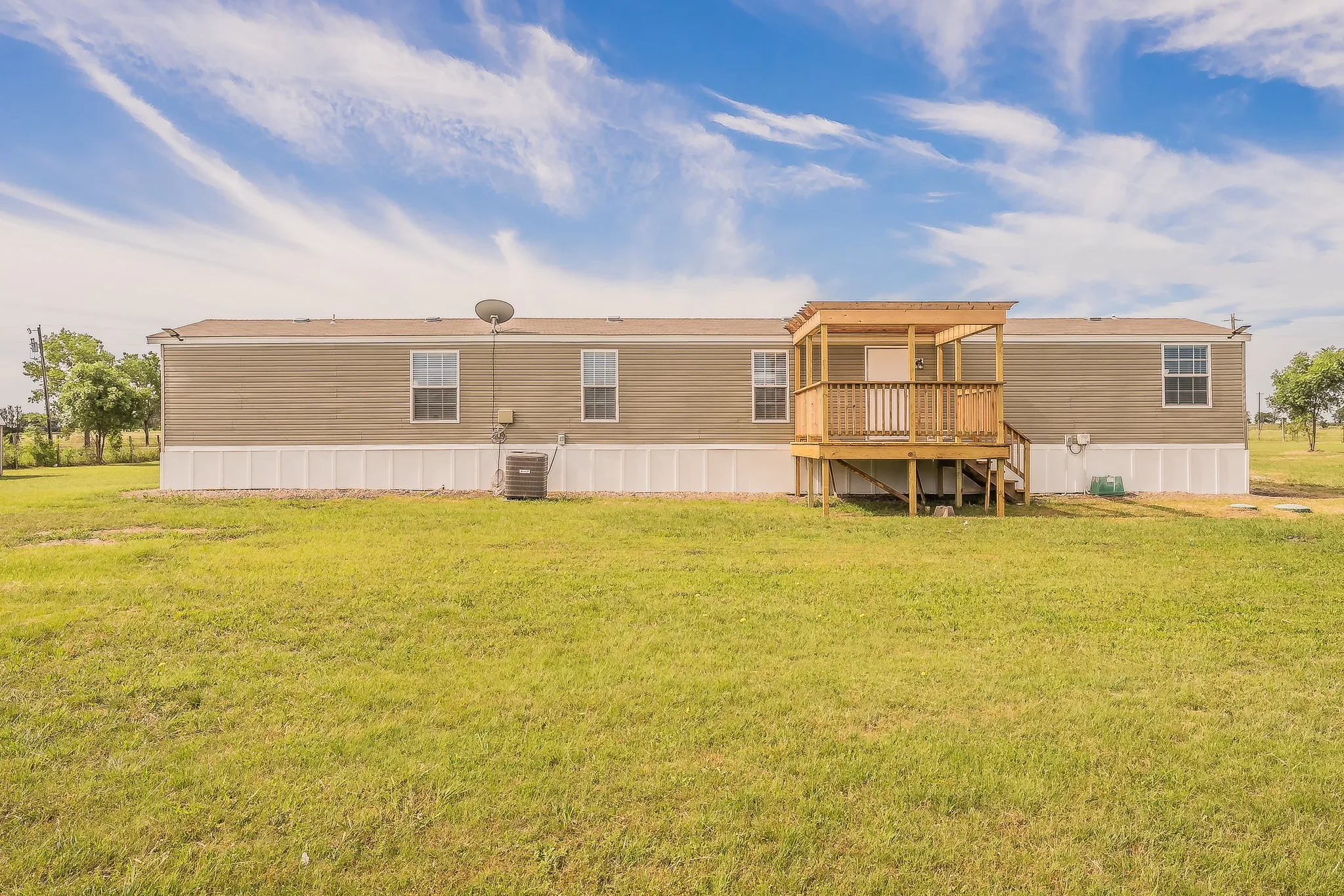 Private covered back deck overlooking wide open acreage views  perfect for relaxing or entertaining.