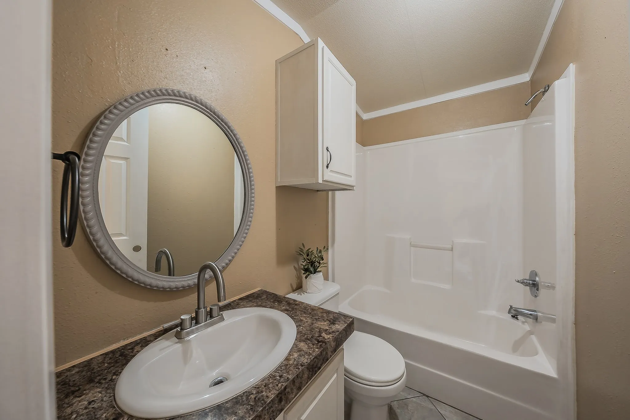 Full second bathroom with vanity, framed mirror, storage cabinet, and tub/shower combo