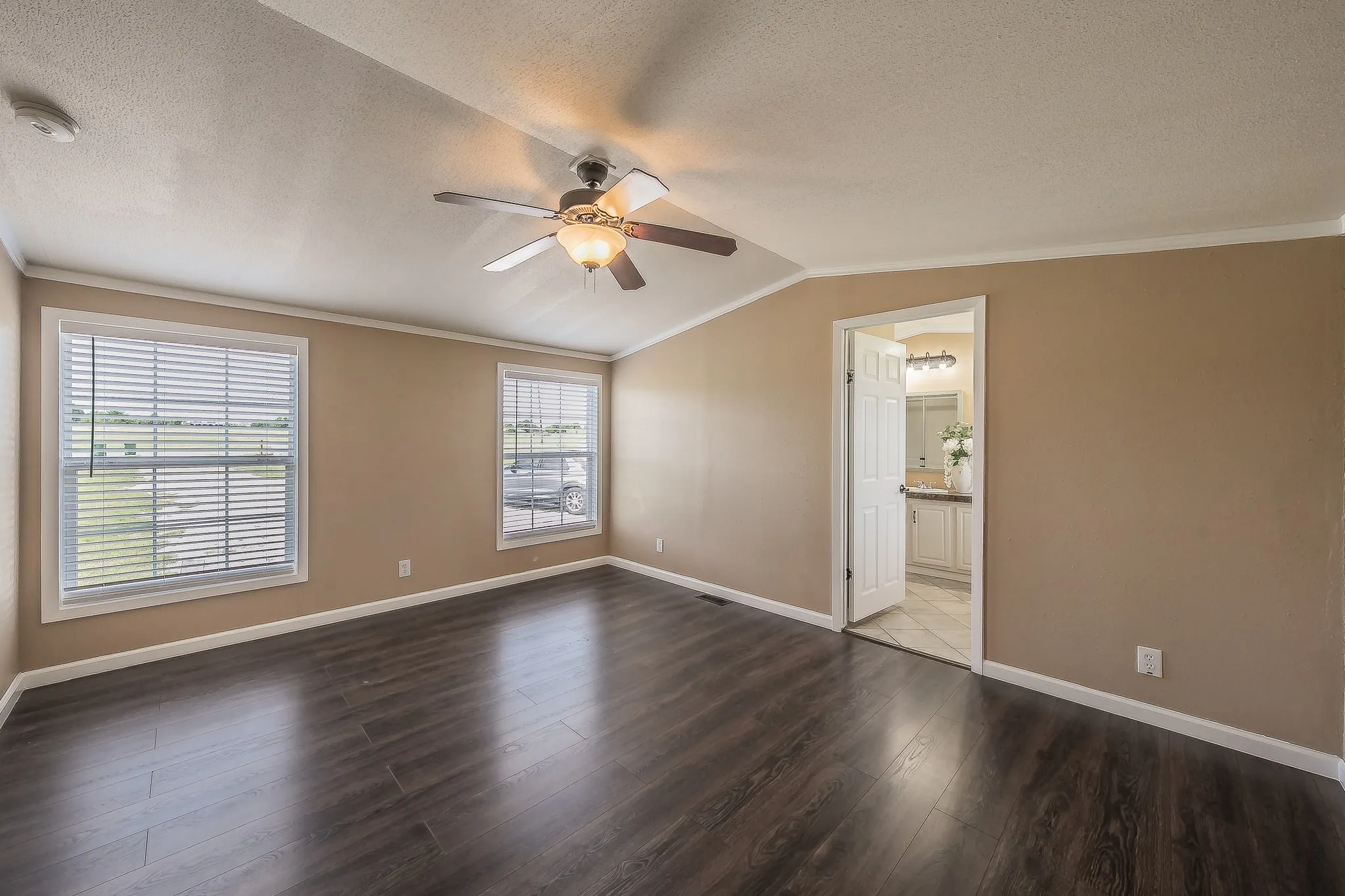 Spacious primary bedroom with natural light and ensuite bath access.