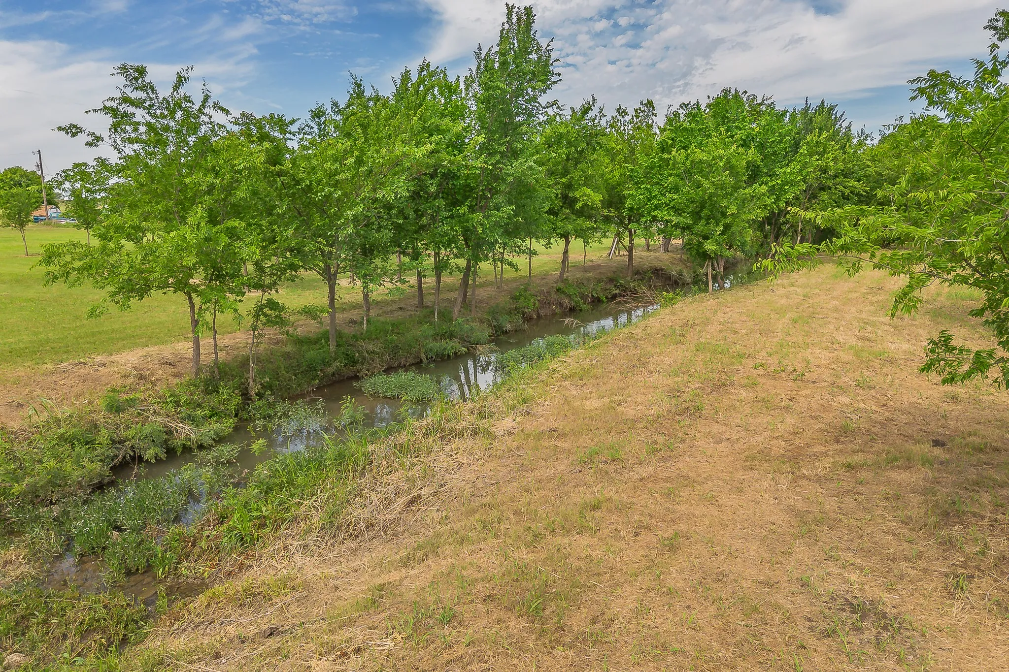 Scenic creek views surrounded by trees and open green space.