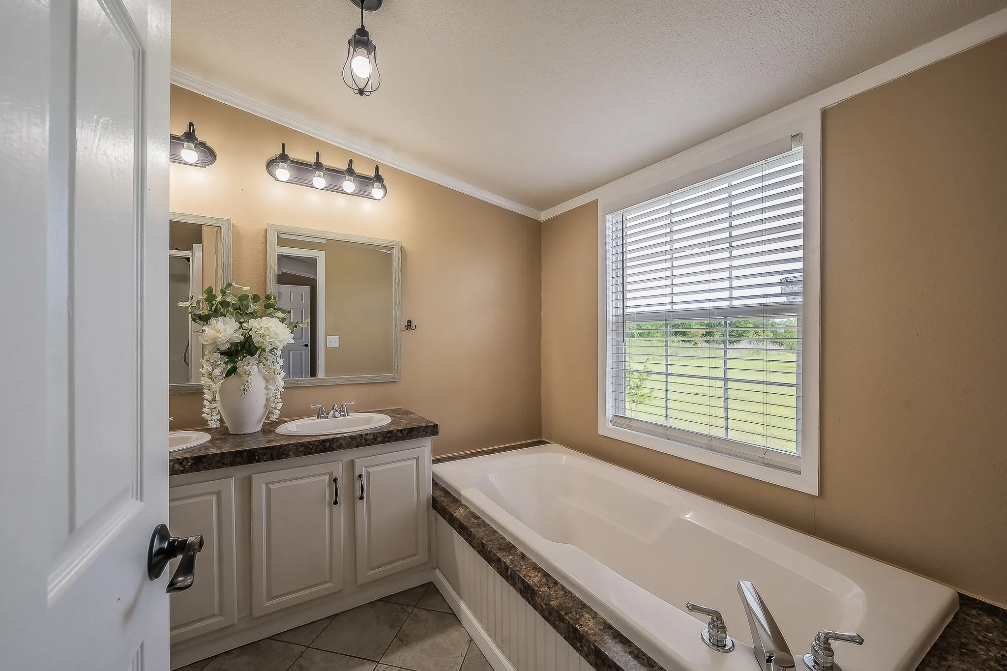 Primary bathroom featuring soaking tub, and large window