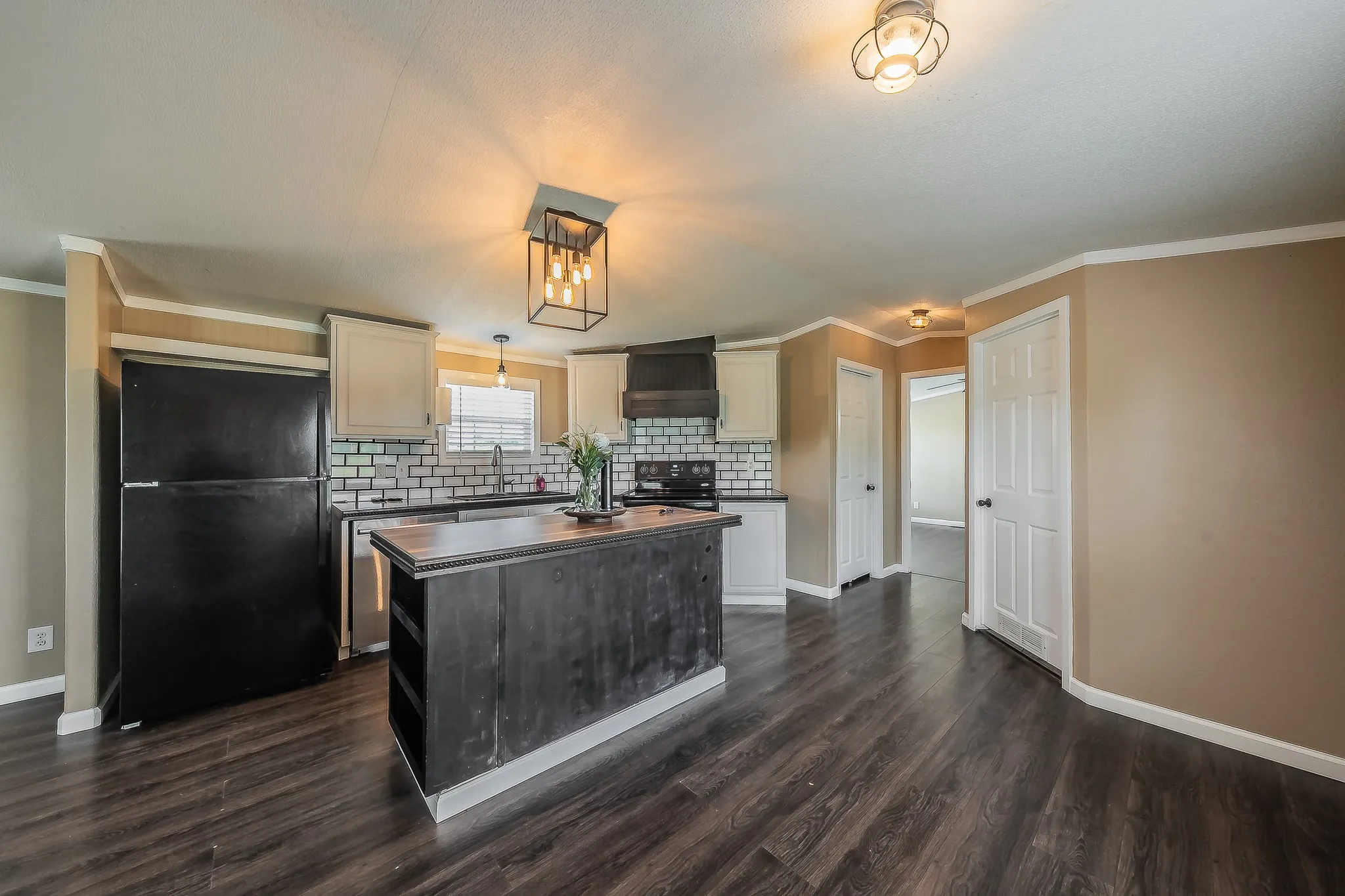 Bright kitchen with backsplash, ample cabinetry, and large center island.