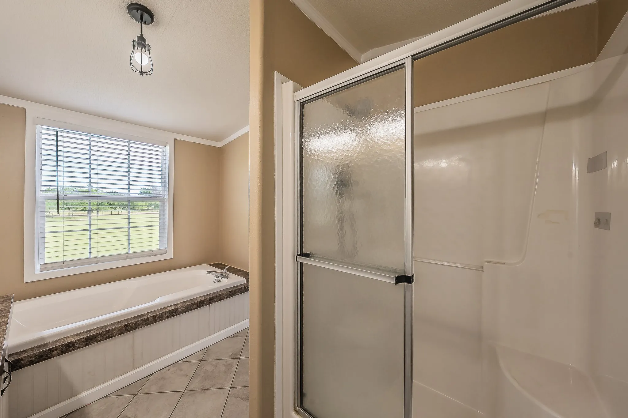  Primary ensuite featuring a separate glass-enclosed shower and relaxing soaking tub.