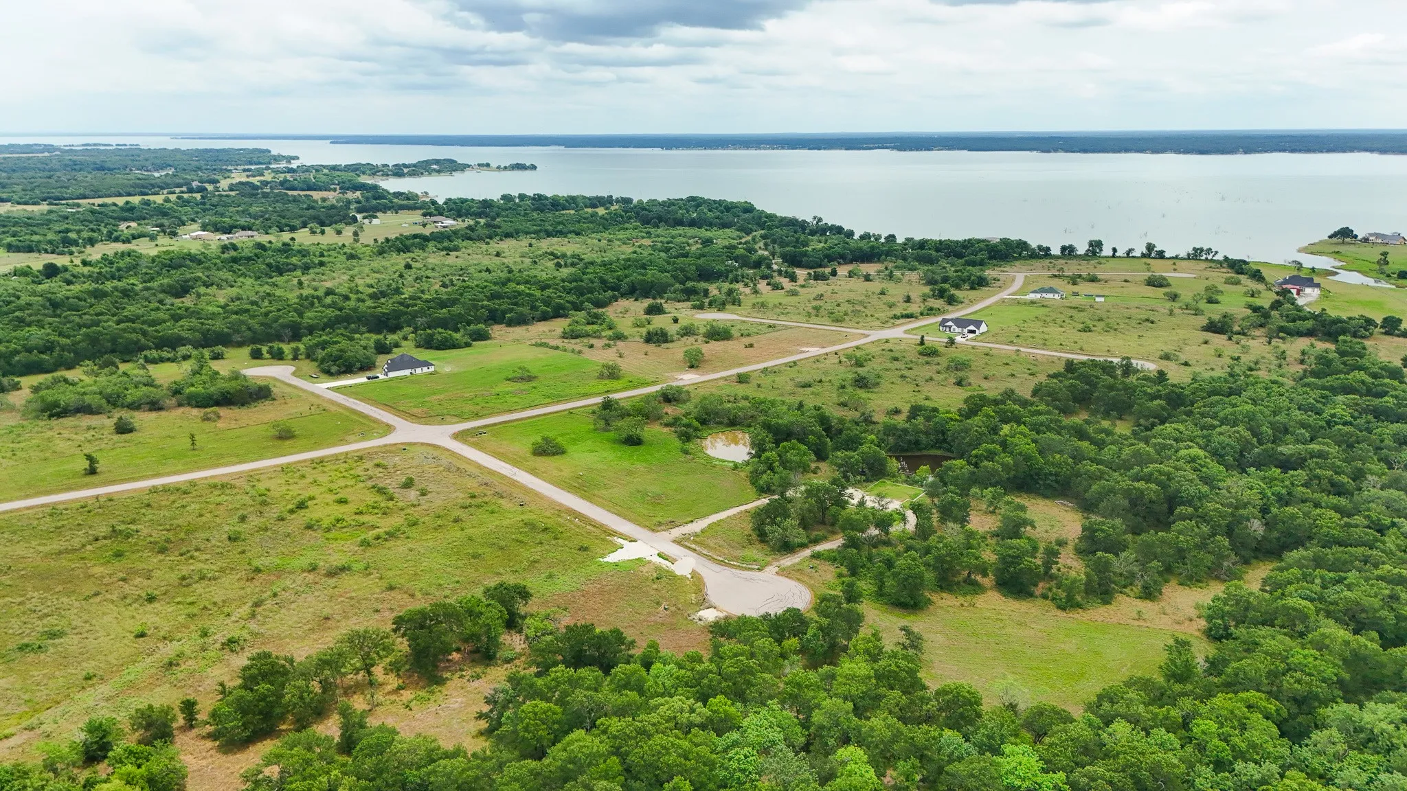 Expansive land parcels featuring established roads, mature trees, open grassy areas, and waterfront access
