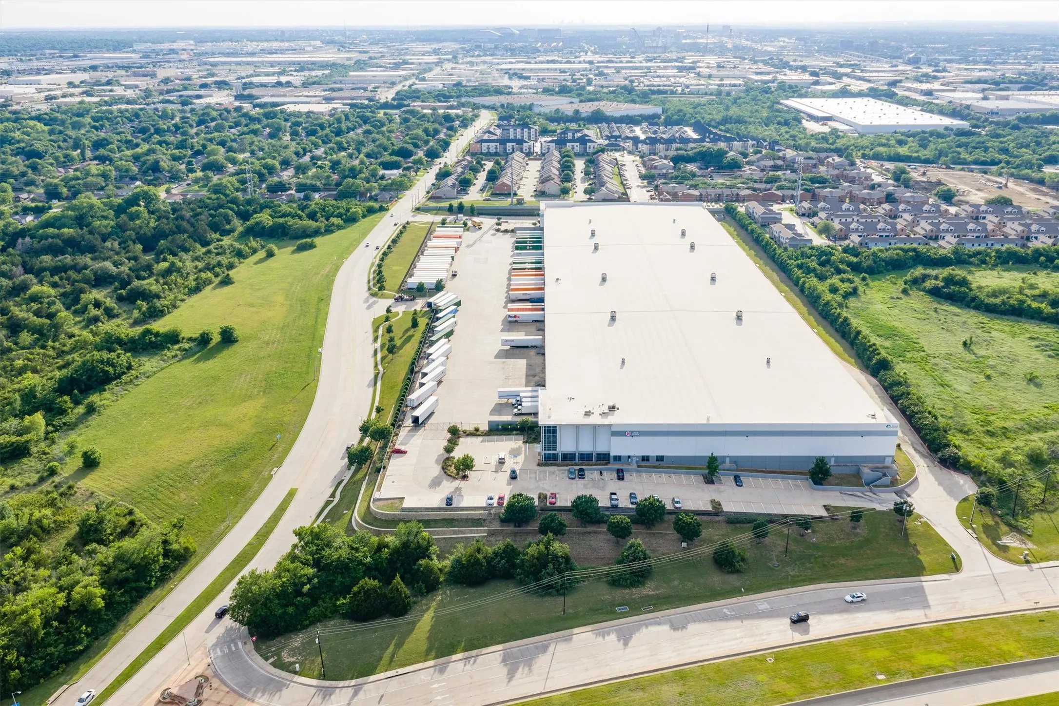 Expansive industrial facility featuring a large flat roof, multiple loading docks, and extensive parking areas